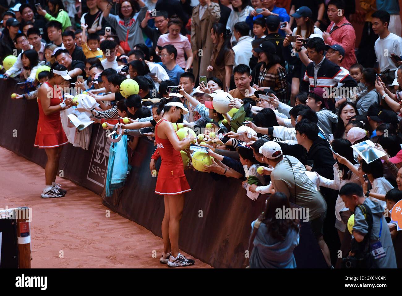 Changsha, China's Hunan Province. 13th Apr, 2024. Wang Xinyu (front, R)/Guo Hanyu (front, L) of China sign autographs for fans after the women's doubles match against Kim Dabin/Park Sohyun of South Korea at the Billie Jean King Cup 2024 tennis tournament Asia-Oceania Group I match in Changsha, central China's Hunan Province, April 13, 2024. Credit: Chen Zhenhai/Xinhua/Alamy Live News Stock Photo