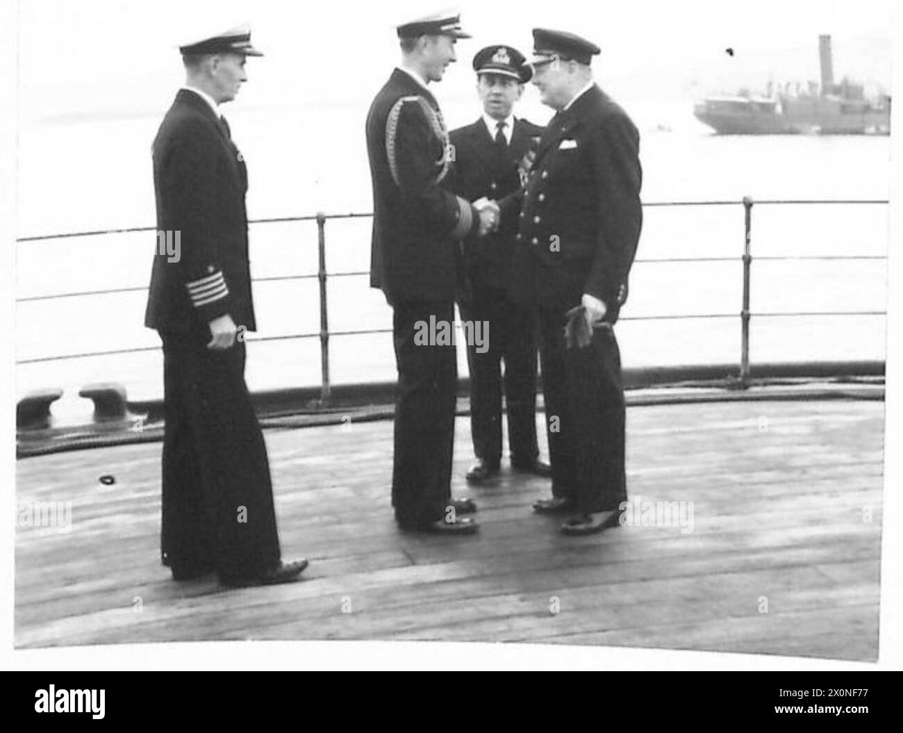 PRESIDENT MEETS PRIME MINISTER - Prime Minister greets President Roosevelt's Naval ADC., Captain Beardall, and the Commander-in-Chief, US Atlantic Fleets Chief of Staff, Captain Badger, who were the first to come aboard H.S.M. Prince of Wales. Photographic negative , British Army Stock Photo