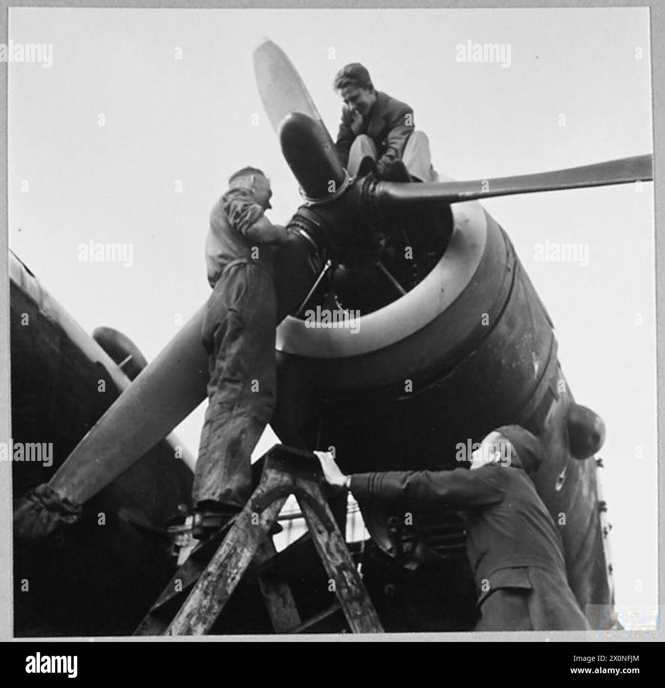 Photograph showing an RAF engineer officer supervising aircraft repairs ...