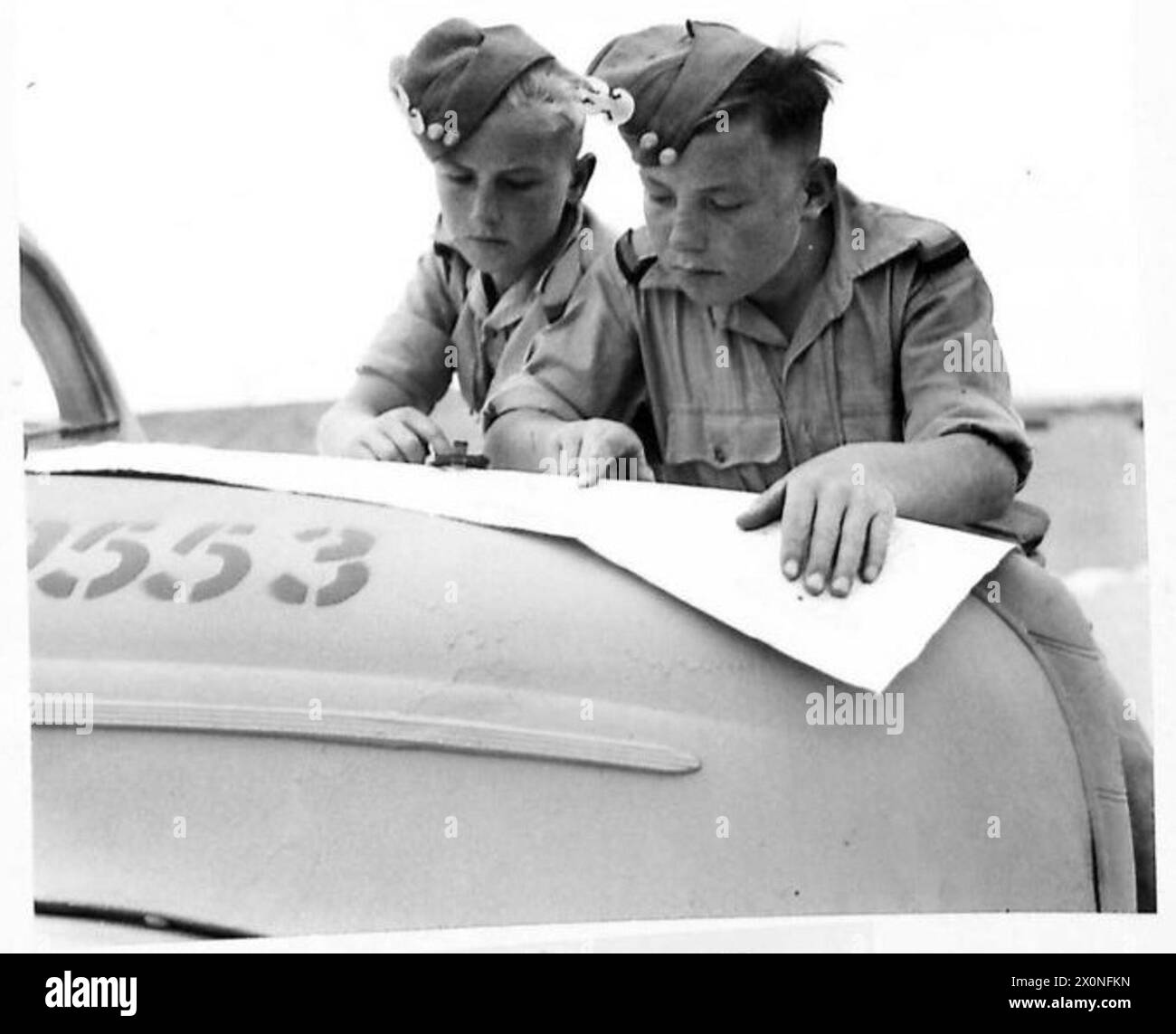 BOY SIGNALLERS OF FIVE NATIONS - Two Polish boys study their map before going off into the 'blue' on their motorcycles, 21 April 1943. Early in 1942 Boys' Signals Company was formed in the Middle East to train boys for signals work so that men could be released for work in the Middle East countries. Many boys of school leaving age were available in Egypt, eager to help the Allied cause, but few were English and fewer still of the rest spoke English. There were Poles, Greeks, Cypriots, Maltese and others who had to be first taught the English language.The Signals units were combed for English t Stock Photo