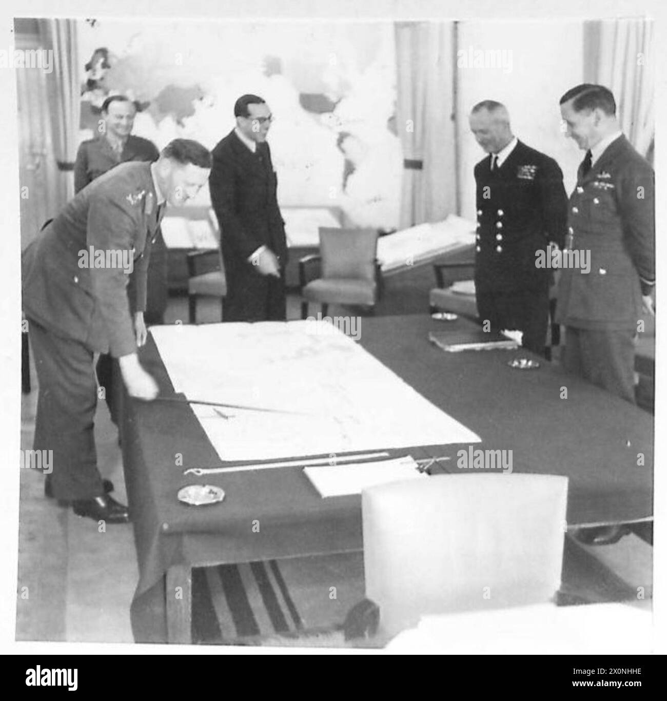 CONFERENCE OF THE THREE M.E. SERVICE CHIEFS - General Sir Claude Auchinleck, the C-in-C with Sir Walter Monckton (acting Minister of State), Admiral sir Andrew Cunningham (Mediterranean Fleet) and Air Marshal Sir A. Tedder. The C-in-C is pointing to a map. Photographic negative , British Army Stock Photo
