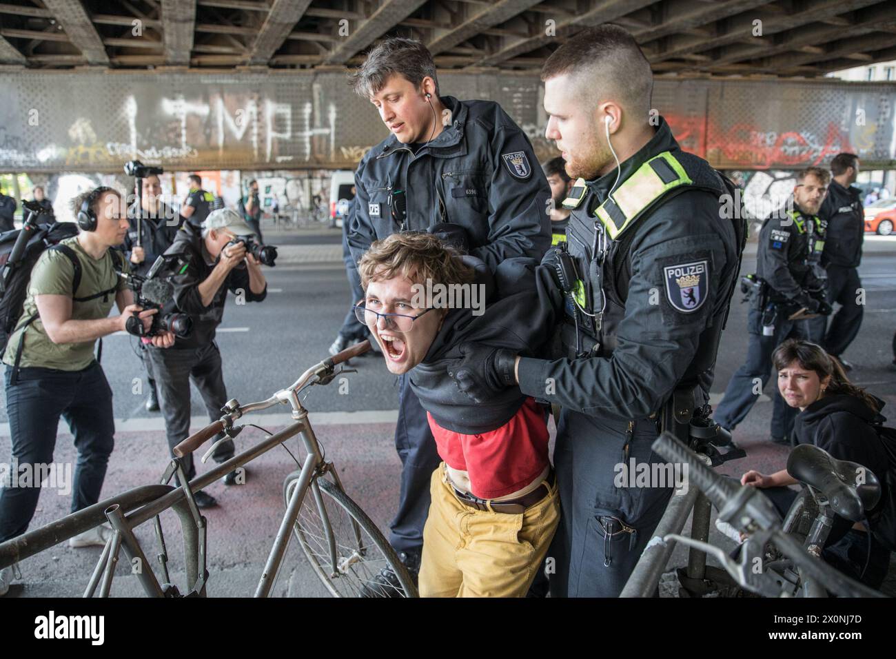 Continuing their efforts to draw attention to urgent climate issues, the Last Generation, Letzte Generation, activist group members blocked Frankfurter Allee, one of Berlin's oldest and most crucial traffic routes, on April 13, 2024. The Last Generation, a prominent climate activism group in Germany, has become increasingly visible due to their high-profile and disruptive protests targeting major traffic arteries and public spaces. Originating as part of a global wave of environmental activism, the group demands that the German government commit to more aggressive action against climate change Stock Photo