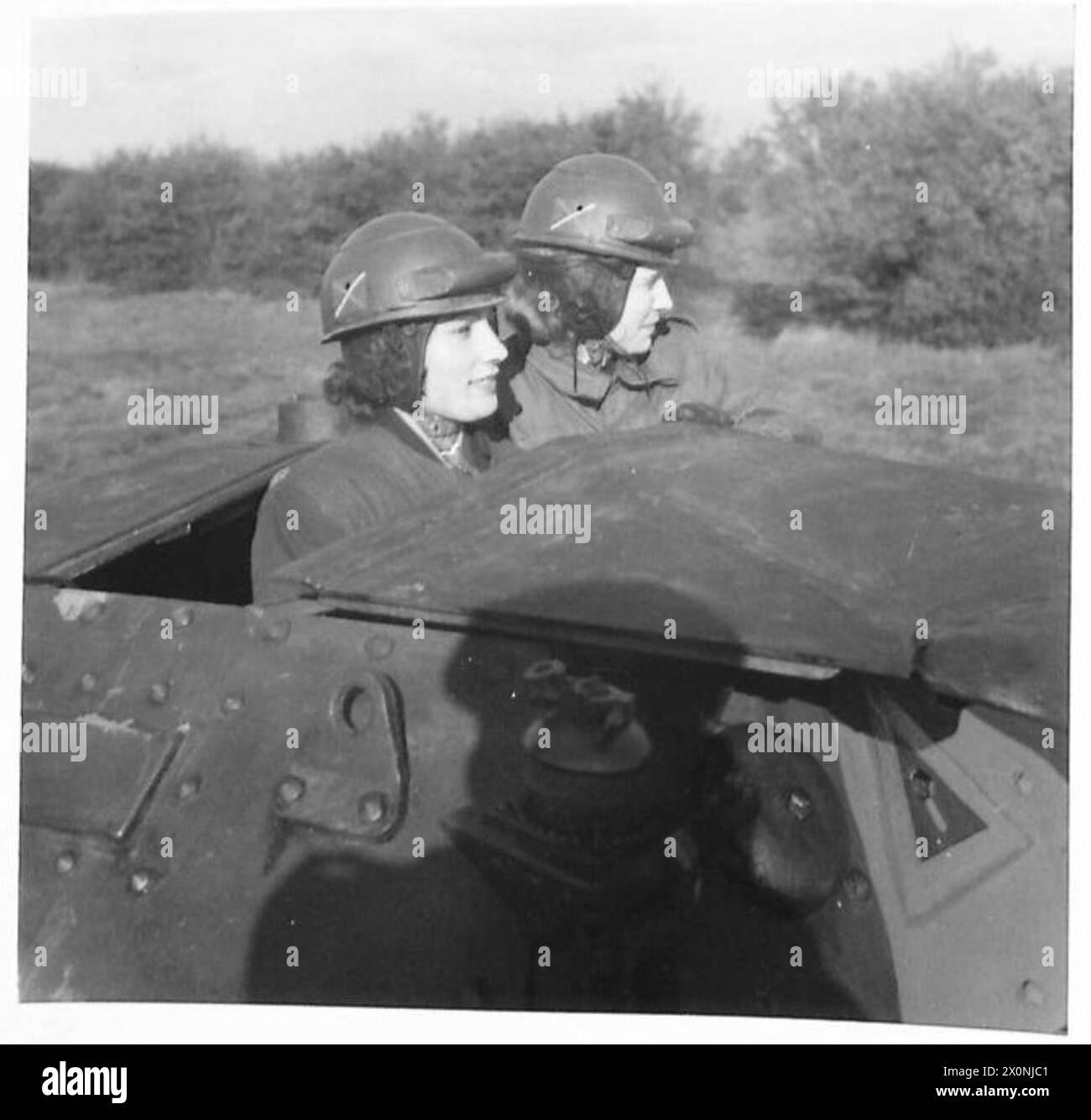 MUNITION GIRLS VISIT THE TANKS - Mrs. E. Tregear and Miss V. Braban go for a ride in one of the tanks. Photographic negative , British Army Stock Photo