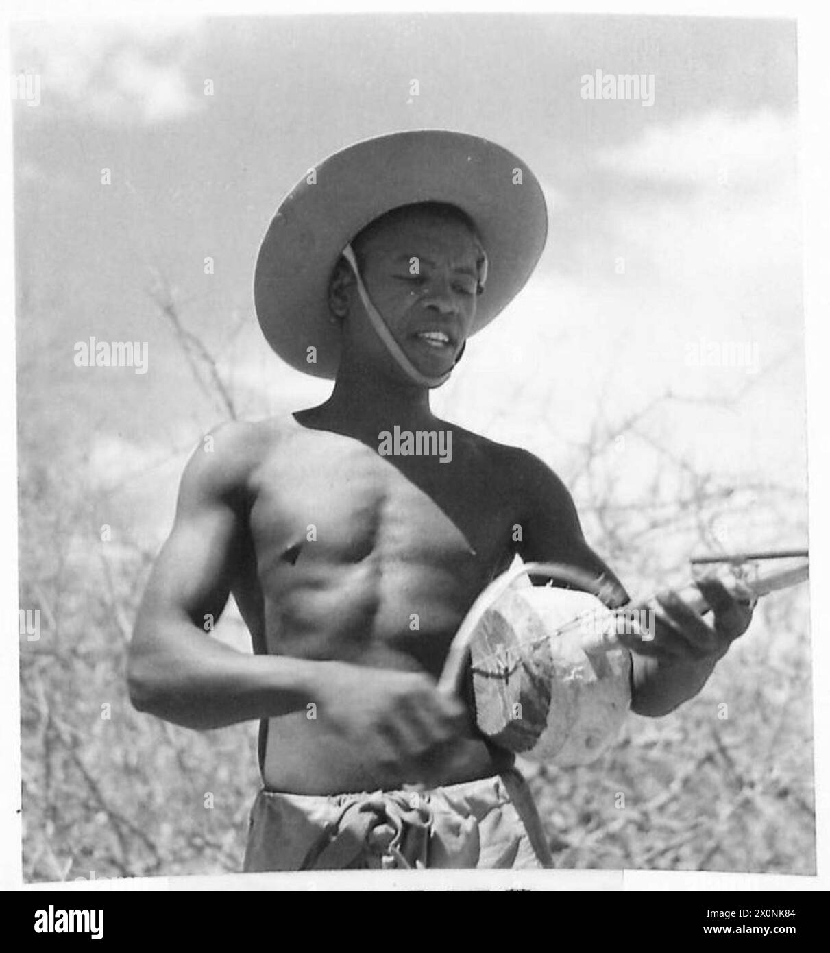 WITH THE KING'S AFRICAN RIFLES ON THE KENYA FRONT - The K.A.R. possess a band. This soldier plays this instrument with a bow and string. Photographic negative , British Army Stock Photo