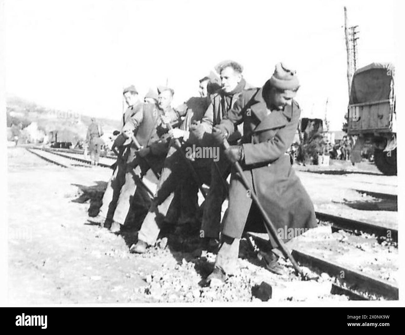 ITALYBRITISH COAL FOR ITALIAN RAILWAYS(M. of I. Request) - The permanent way gang lever a new rail into position. Photographic negative , British Army Stock Photo