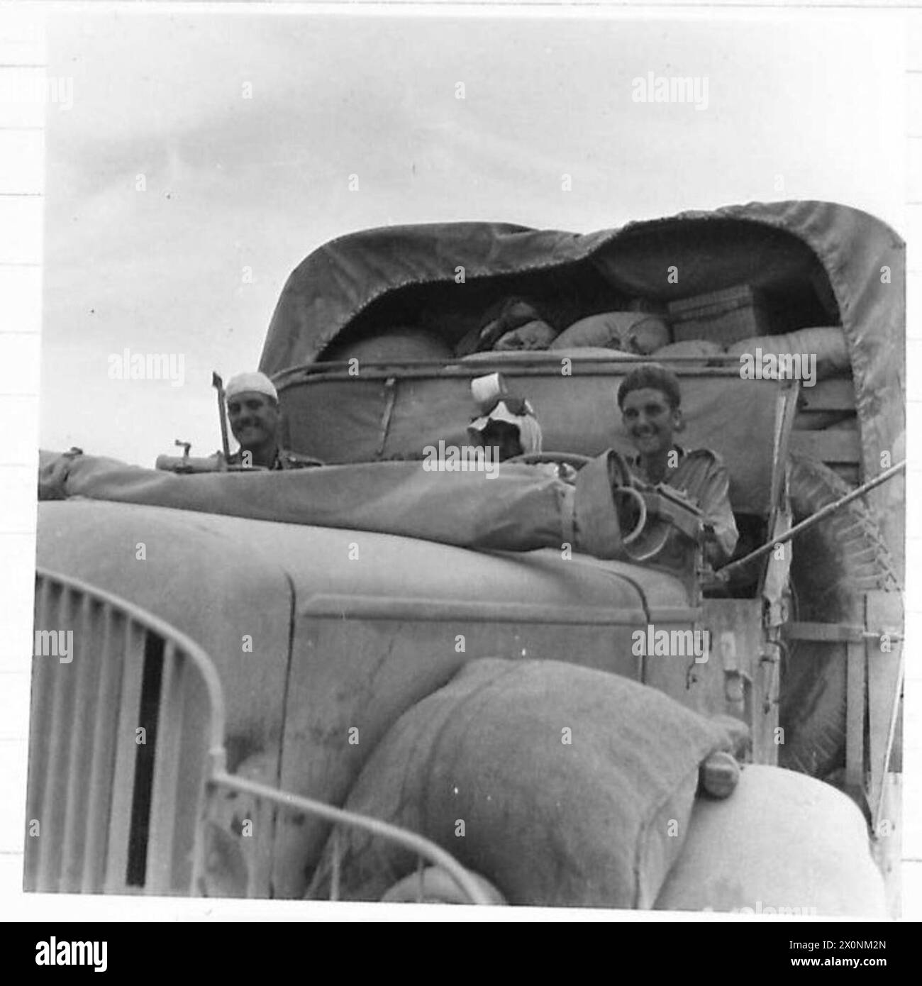 ALLIED TROOPS TRAVEL THREE MILLION MILES KILLING LOCUSTS - A ten-ton lorry in convoy on the road to Hail. Left to right are:-L/Cpl. A Houghton of 289 Stratford Road, BirminghamMohamed, a Saudi Arabian guideDvr. R. Knights of 202 Clapham Road, Stockwell, London S.W.9 , United Nations Organisation [UNO] Stock Photo