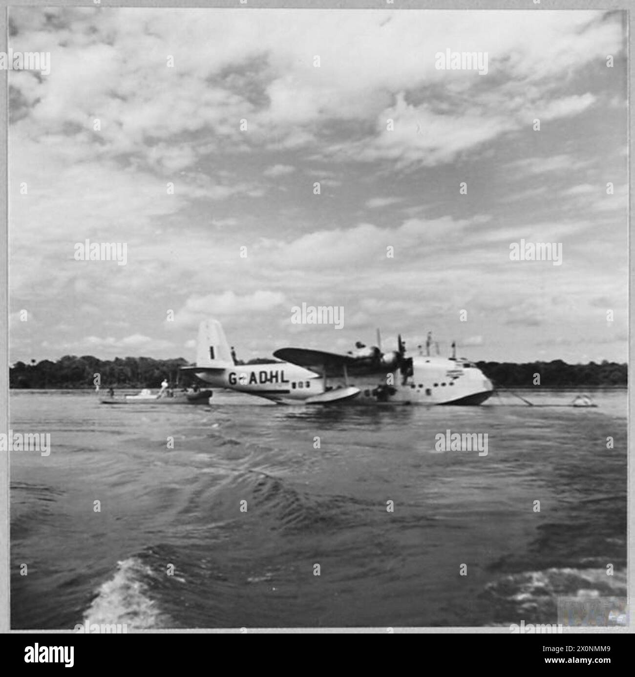 BRITAIN'S CIVIL AIRLINES CARRY ON IN WAR TIME - For story see CH.14052 Picture (issued 1944) shows - The BOAC Empire flyingboat 'CANOPUS' refuelling at a halt on the Congo River during a trans-African flight. A local peculiatiry is that owing to the swiftness of the stream, the refuelling launch has to make fast to the flyingboat's stern. Photographic negative , Royal Air Force Stock Photo