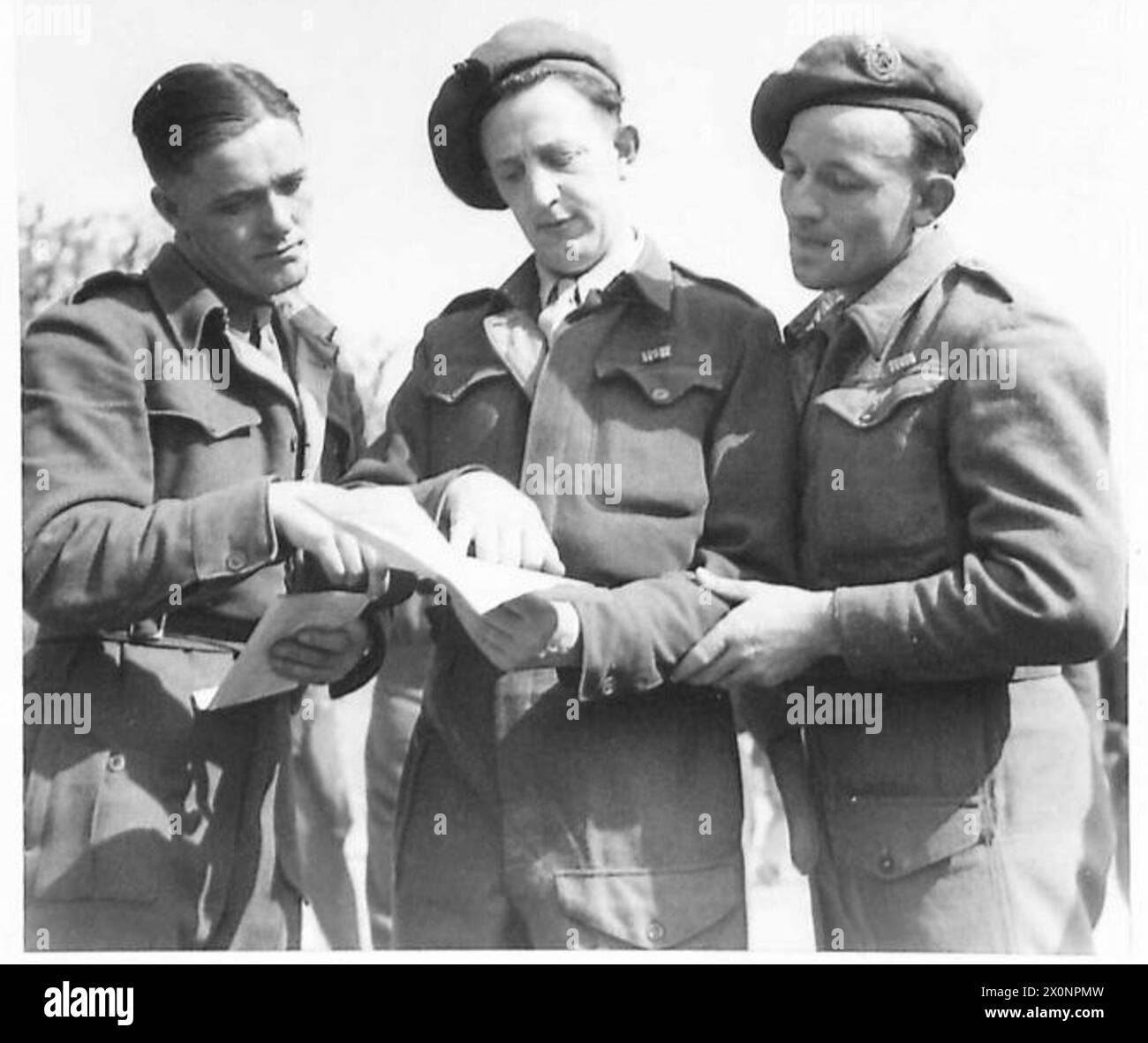 ITALY : RACE MEETING AT FLORENCE - Spr. D. Little (left) of Manchester; Dvr. John Elio of Manchester, and Dvr. Bill Burney also of Manchester, study the card to pick the winner of the 'next one'. Photographic negative , British Army Stock Photo