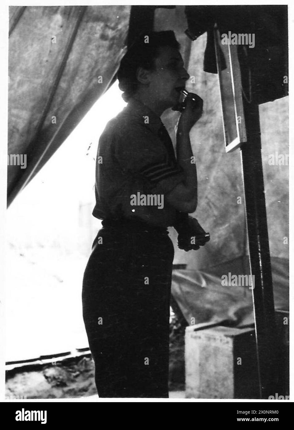 WOMENS' SERVICES IN NORMANDY - Sgt.Catherine Marquis of Glencoe, Argyllshire, putting the finishing touches to her make-up before going on duty at one of the NAAFI Institutes. Photographic negative , British Army, 21st Army Group Stock Photo