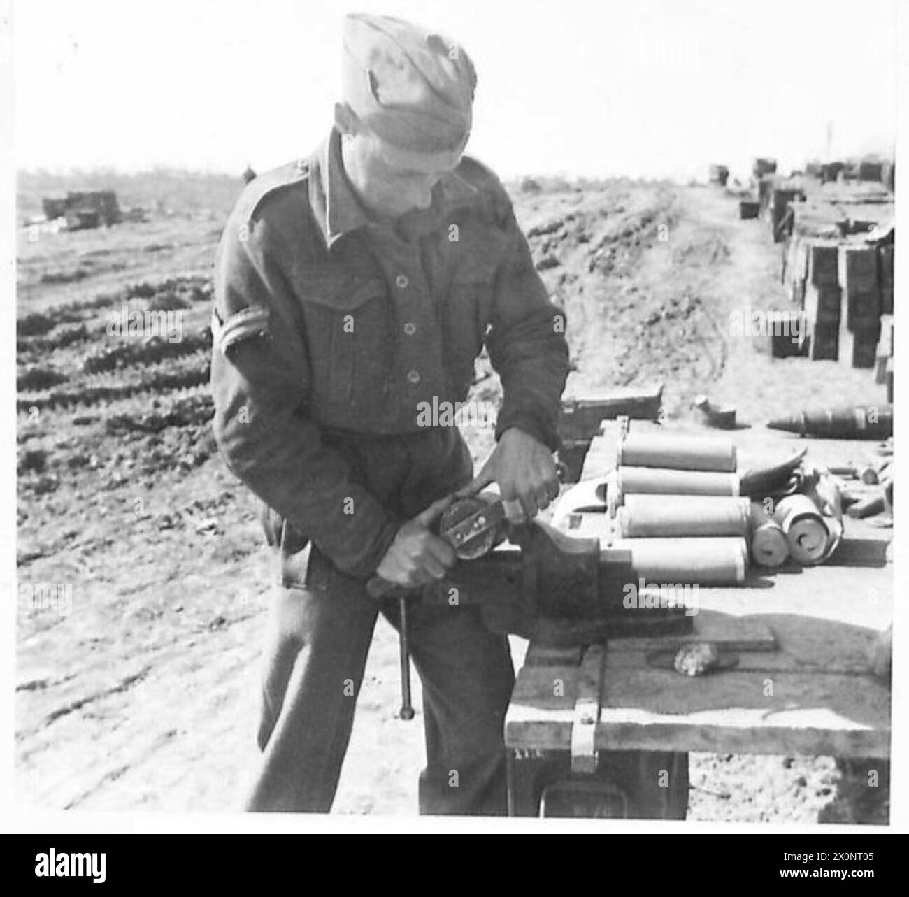 EIGHTH ARMY : PSYCHOLOGICAL WARFARE - Cpl. Sparks of Darlington screws up a base plate for checking the loading of the leaflets. Photographic negative , British Army Stock Photo