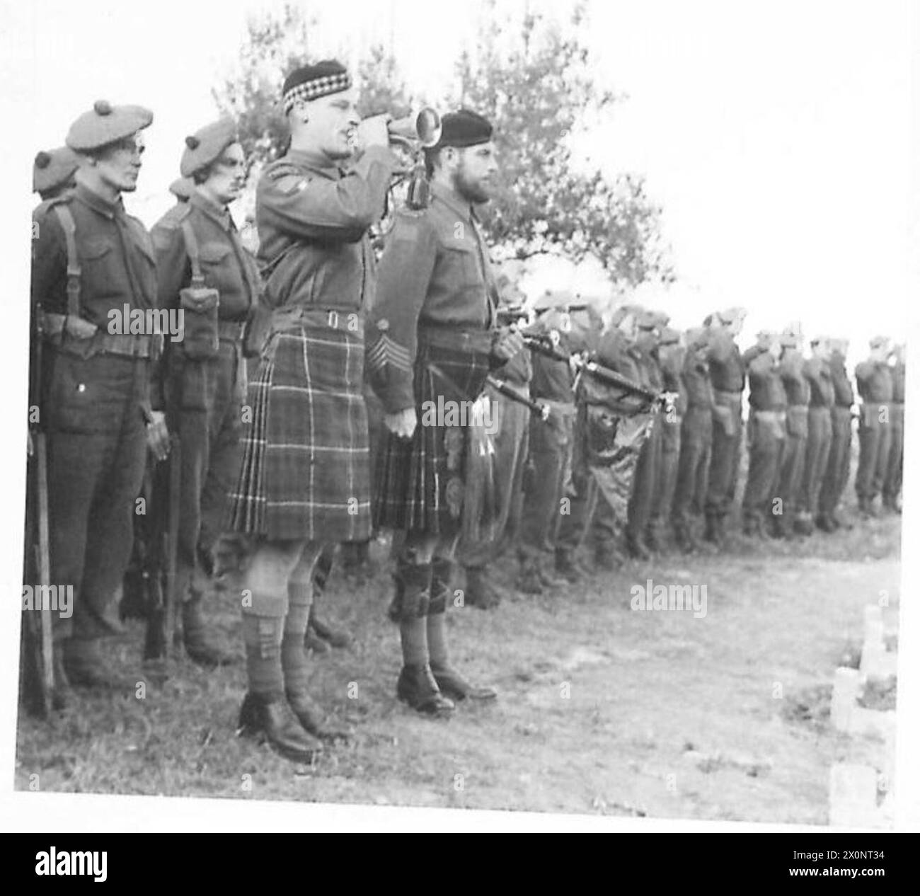 THE BRITISH ARMY IN NORTH AFRICA, SICILY, ITALY, THE BALKANS AND AUSTRIA 1942-1946 - Standing beside Pipe-Major Esson of Vancouver, Drummer George Palmer of Vancouver, sounds the 'Last Post'. Photographic negative , British Army Stock Photo