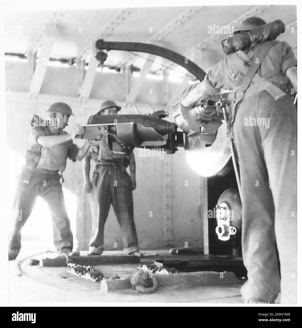 A shell is loaded into a gun from the loading tray during British Army ...
