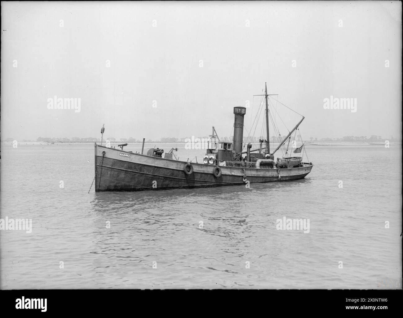 Marinus at anchor, showing the vessel stationary in open water with deck, superstructure, and mooring equipment visible. The ship is prepared for maritime operations. Stock Photo
