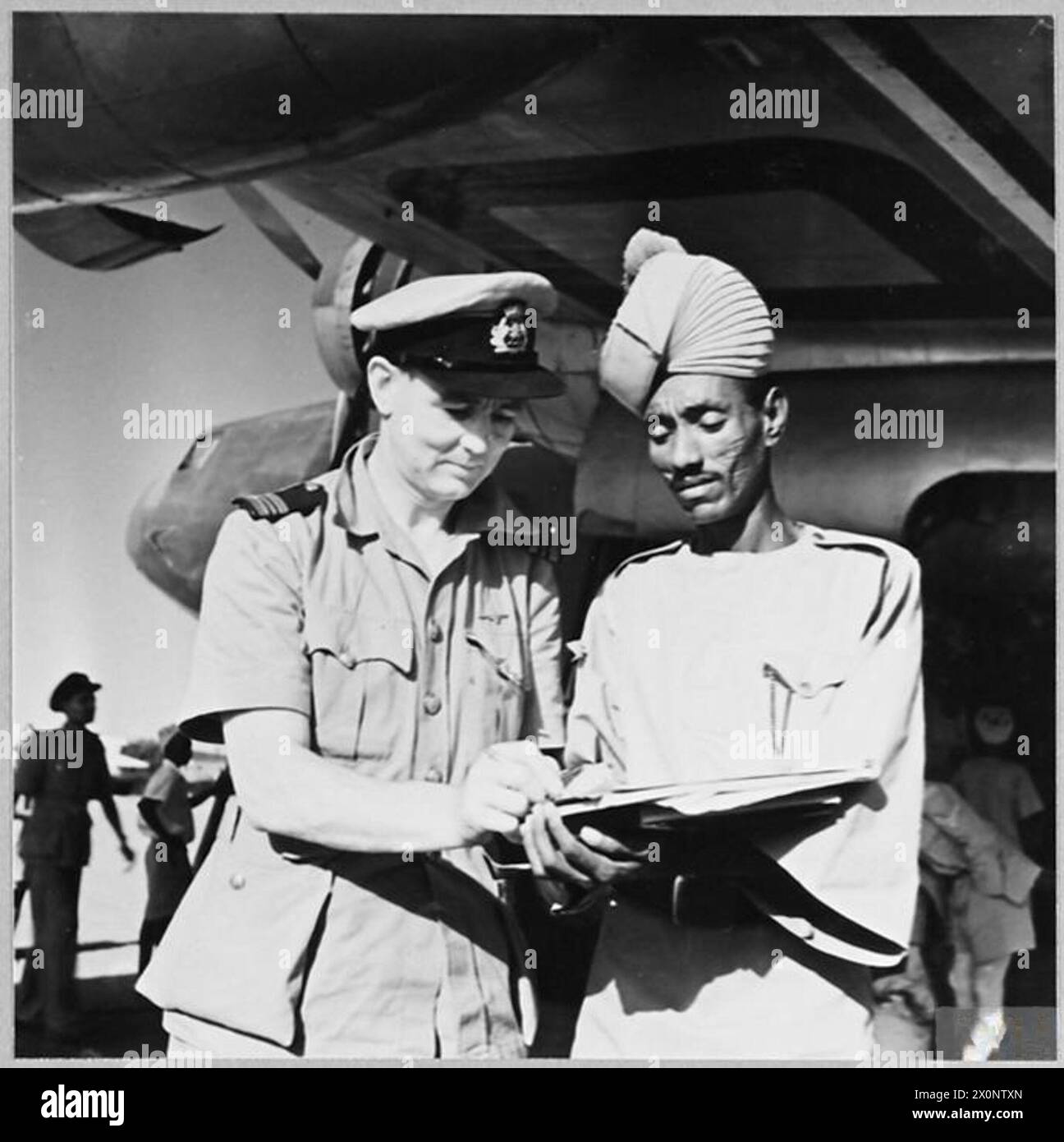 Captain W.G. Buchanan, a BOAC pilot, is shown signing a control sheet ...