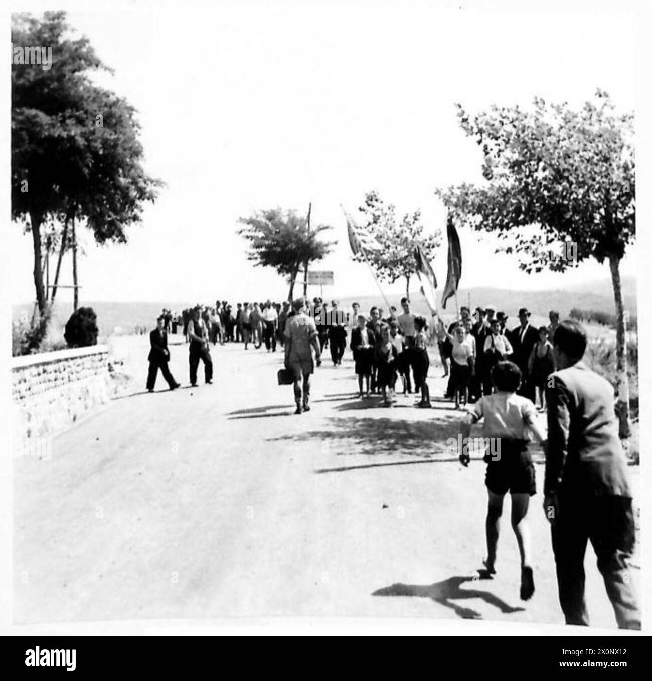 INVASION OF ITALY - 8TH ARMY - A great welcome was accorded to first British troops to enter Maida, province of Calaria, the enemy having pulled out six hours previously. Several English-speaking inhabitants who had lived in America organised this welcome and made rough American and British flags. Nearly 140 years ago, during the Napoleonic Wars, Maida was the scene of battle when British troops invaded Italy under the command of Sir John Stuart. Photographic negative , British Army Stock Photo