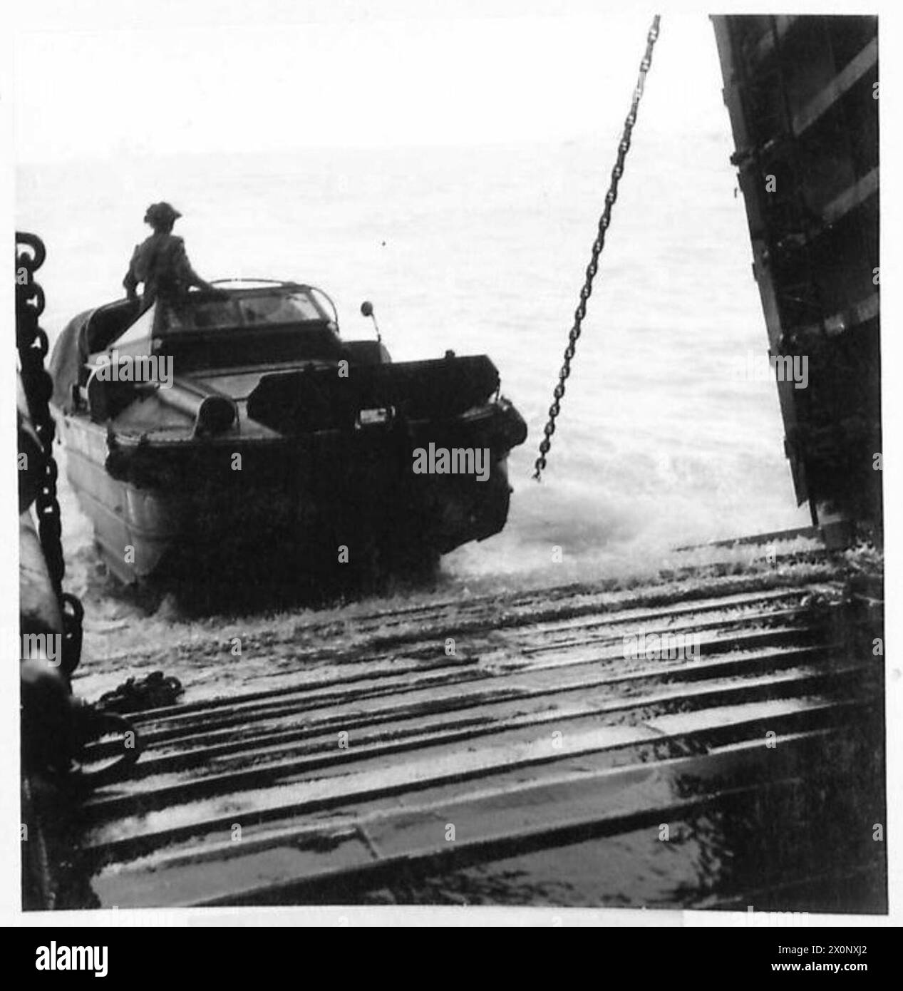 A DUKW amphibious vehicle carrying tank and SP gun ammunition departs a ...