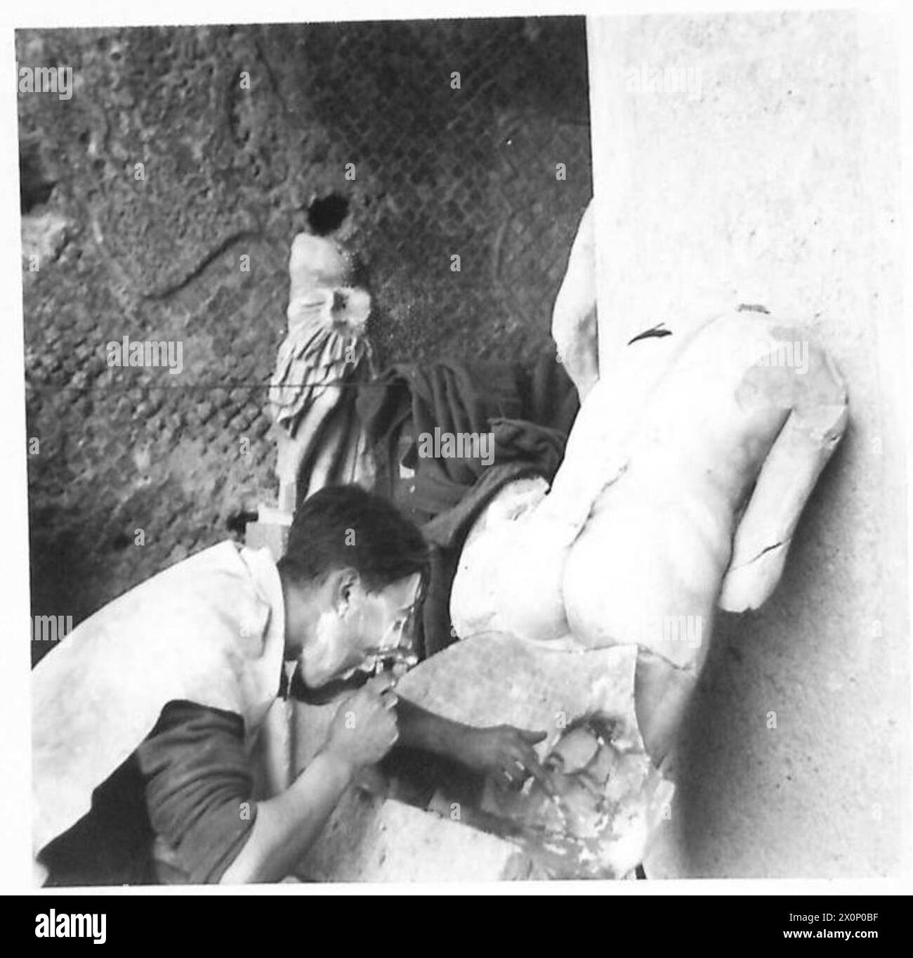 THE BRITISH ARMY IN NORTH AFRICA, SICILY, ITALY, THE BALKANS AND AUSTRIA 1942-1946 - Rfn. R. Dean of Shepherds Bush, London make use of a statue to support his mirror whilst shaving. Photographic negative , British Army Stock Photo