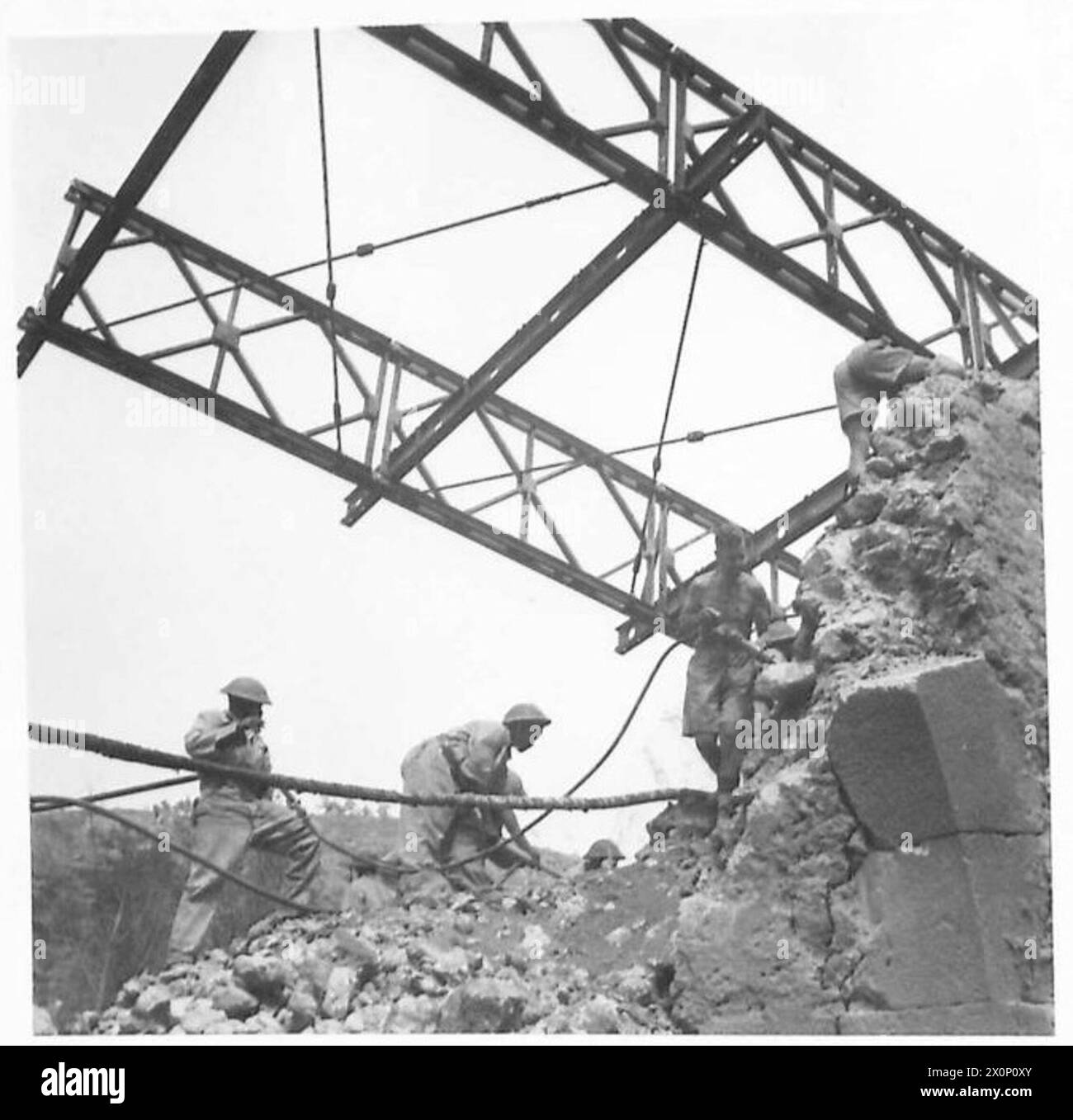 EIGHTH ARMY : BRITISH TROOPS IN ARCE - The bridge into Arce, which was blown by the Germans at night, was quickly replaced by a Bailey bridge which was almost completed by the morning. Royal Engineers and Bechuana Pioneers are seen at work on the bridge. Photographic negative , British Army Stock Photo