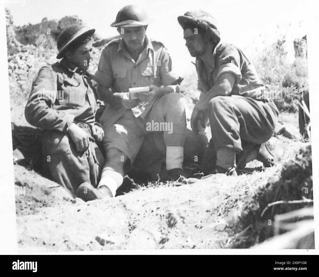 THE BRITISH ARMY IN NORTH AFRICA, SICILY, ITALY, THE BALKANS AND AUSTRIA 1942-1946 - Major David MacGregor-Young of Morelloe, Cricket Hill, Tayeley (centre) explains the tactical situation to two members of an anti-tank gun crew - Fus. W. McNamara, of 15 Broadway, Ardrossan, Scotland (left), and Fus. J. Stennett of 228 Hogh Lane, Wombwell Barnsley. Photographic negative , British Army Stock Photo