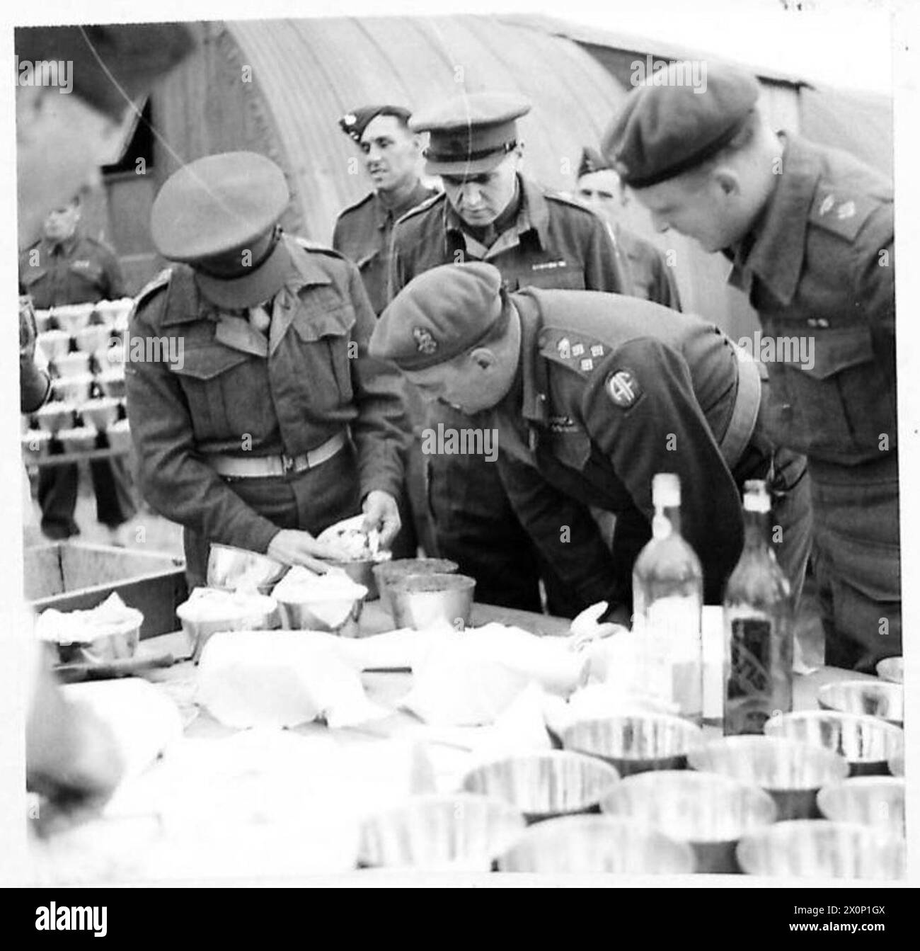 NORTH AFRICACHRISTMAS PUDDINGS FOR THE TROOPS - Capt. Langelaan, Commandant of the Training Centre, demonstrated to the Brigadier the method of preparing the puddings for cooking. Photographic negative , British Army Stock Photo