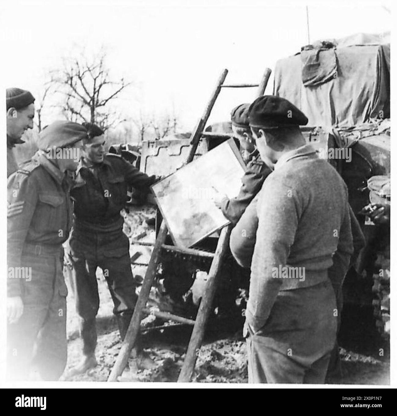 THE BRITISH ARMY IN NORTH AFRICA, SICILY, ITALY, THE BALKANS AND AUSTRIA 1942-1946 - Great interest in the Russian drive towards Berlin is shown in the New Zealand Division, and each Battalion has its map of the Russian and Western battle lines, which is kept up to date by the 'I' officer. Men of the 26 Btn back for a few hours at Btn HQ are seen studying the map. Photographic negative , British Army Stock Photo