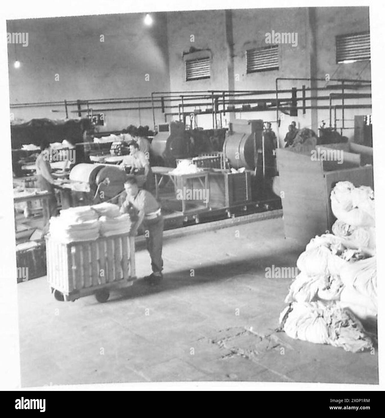 NORTH AFRICAARMY LAUDNRY SERVICENO.1 BASE HOSPITAL LAUNDRY - General view of the interior of the laundry which is in a requisitioned warehouse. Photographic negative , British Army Stock Photo