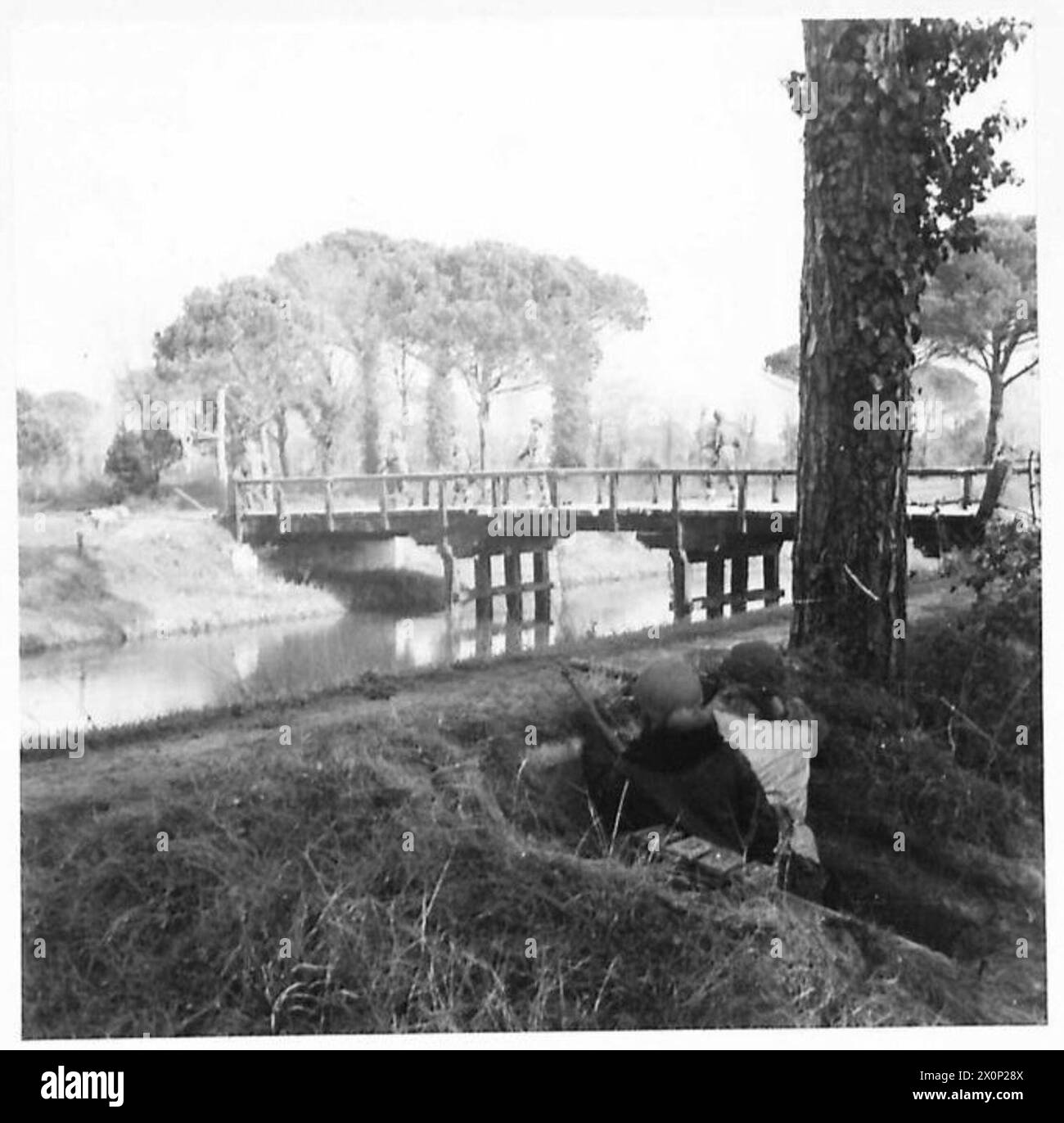 EIGHTH ARMY : VARIOUS - A patrol of 27 Lancers pass over a bridge in the pinewoods five miles North of Ravenna. The bridge is guarded at night by two machine gun posts. Photographic negative , British Army Stock Photo
