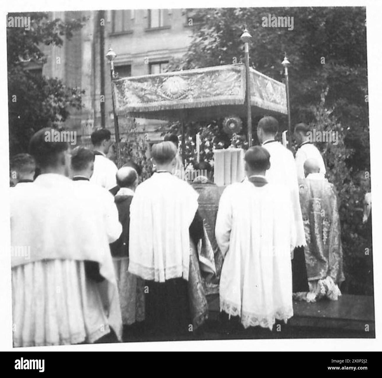 AUSTRIA : CORPUS CHRISTI PROCESSION IN KLAGENFURT - Acting for the Bishop, Msgr. Mayer holds the Holy Sacrament. In the foreground are the Canons and the Metropolitan clergy. Photographic negative , British Army Stock Photo