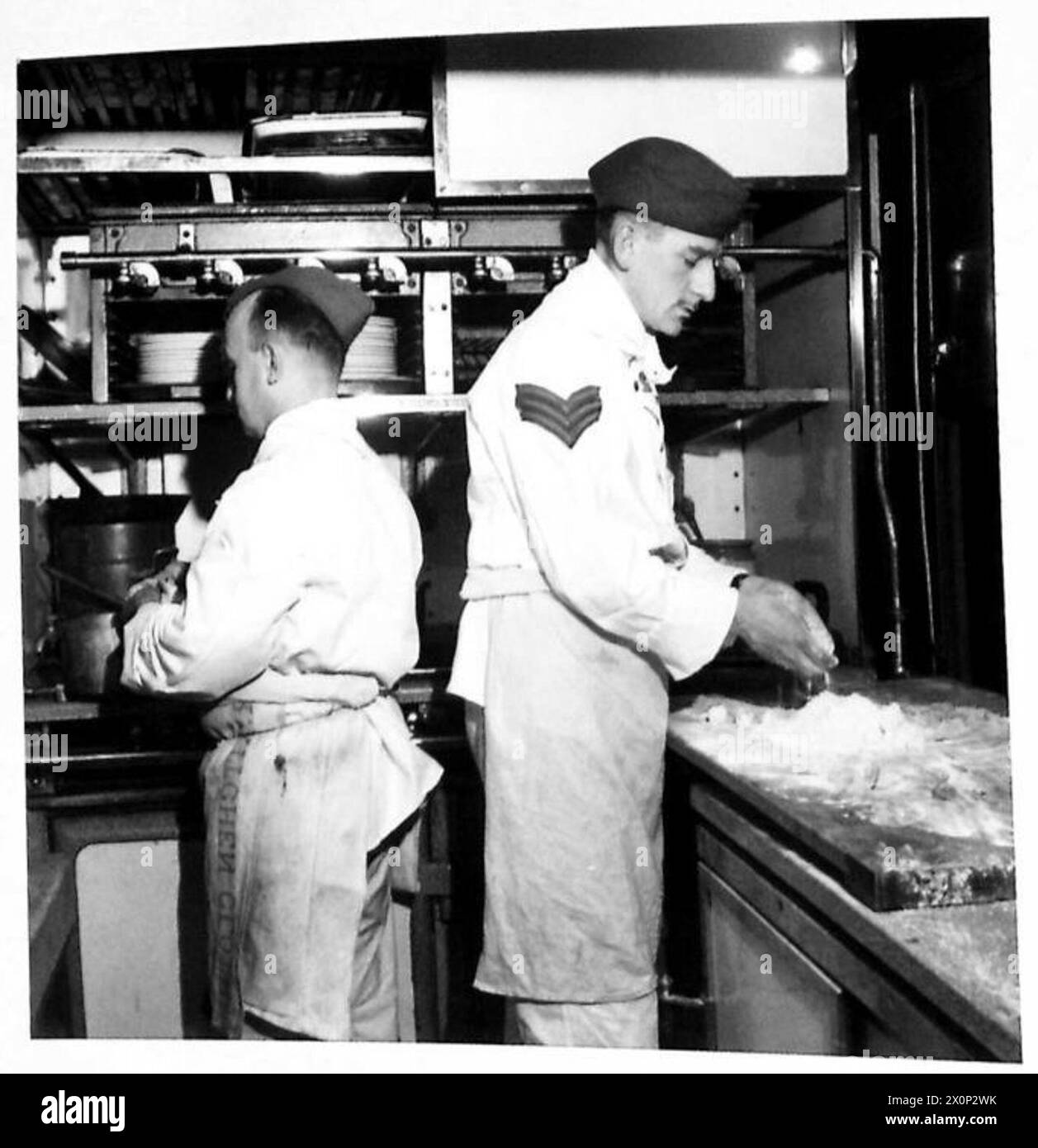 THE C-IN-C's SPECIAL TRAIN - Sergeant J.S. Benzie, A.C.C. of Aberdeen, a peacetime chef with the L.N.E.R. prepares dinner for the C-in-C and his guests. During two years on the train he has cooked for Lord Louis Mountbatten, Prince Olaf of Norway, General Eisenhower and many other distinguished guests. His assistant is Private C.J. Wright of Balham, who in civilian life is chef in a well known London restaurant. Photographic negative , British Army Stock Photo