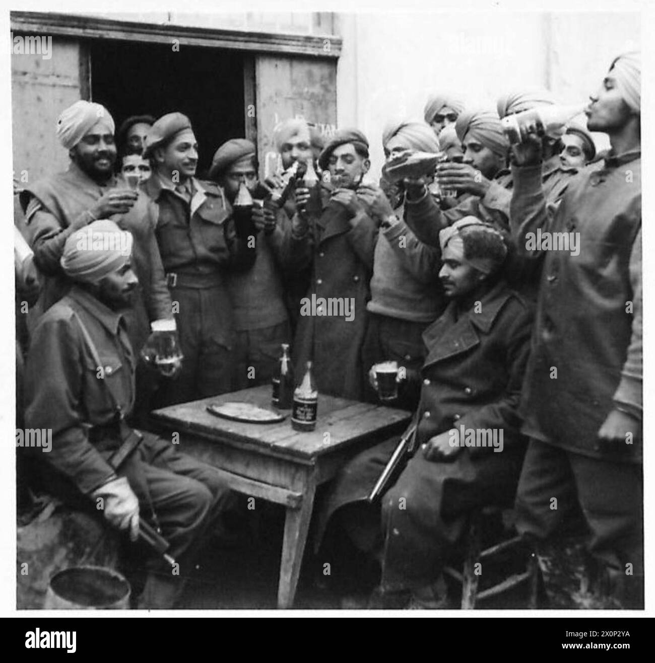 EIGHTH ARMY : VARIOUS - Men of 1/2 Punjab Btn., 10th Indian Division at a toasting party. The Indian Captain QM has wished all present a Happy Christmas, and then joined in a glass of beer. Photographic negative , British Army Stock Photo