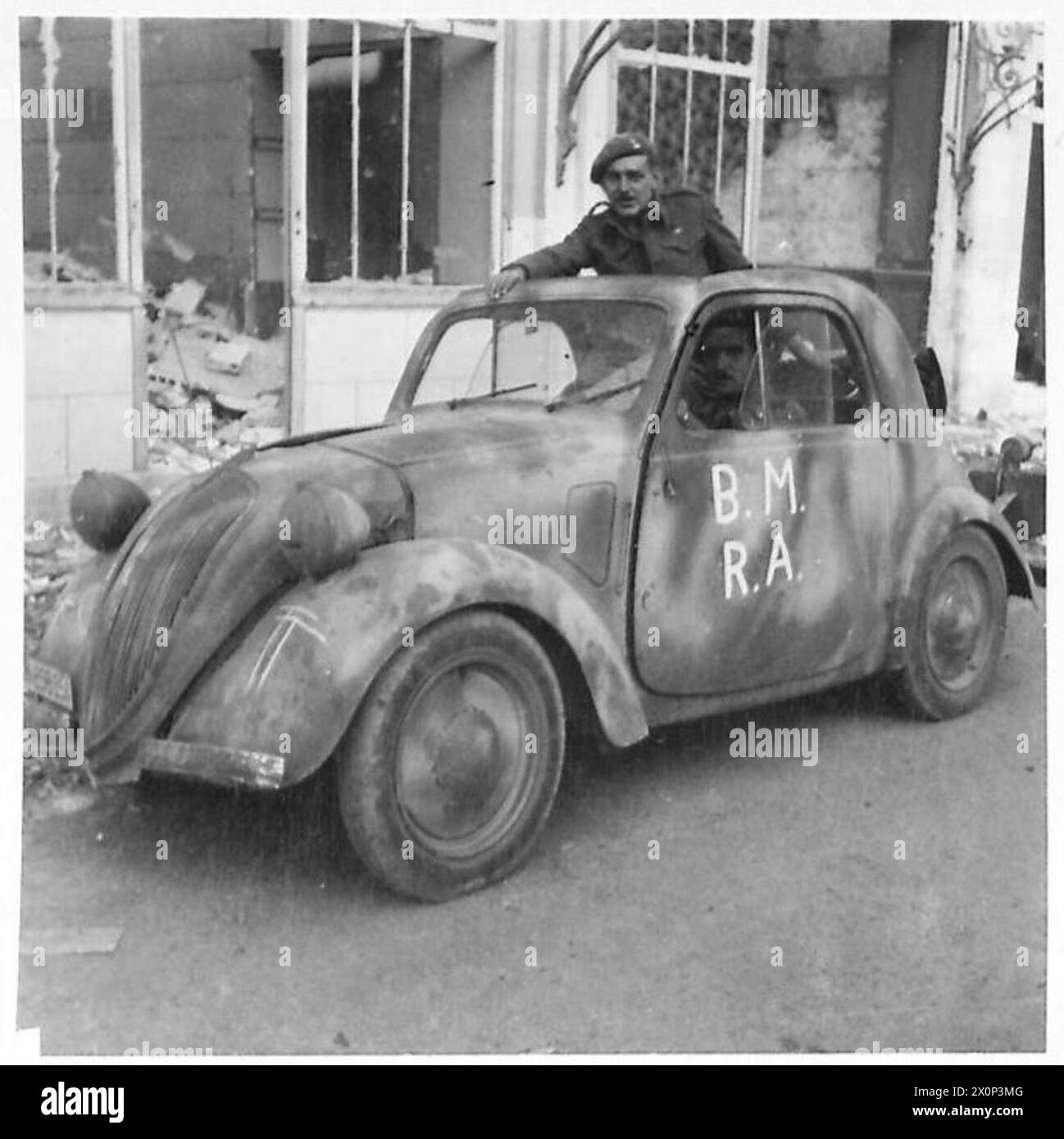 THE BRITISH ARMY IN THE NORMANDY CAMPAIGN 1944 - A Royal Artillery officer, Lt Peter Ronald, and his driver E N Briscomb, of 50th Division, in a French Citroen staff car captured from the Germans, Bayeux, 9 June 1944. The car is marked 'BM RA' (Brigade Major Royal Artillery), and has an arm of service serial ('40') and the 50th Division's 'Tyne Tees' formation sign chalked on the mudguard Stock Photo