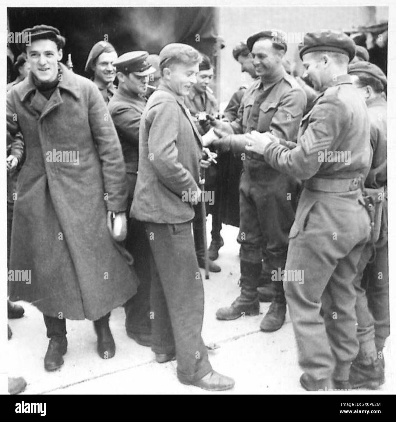 ESCAPED PRISONERS-OF-WAR IN ALLIED HANDS AT BOCHOLT - British soldiers welcome Russin, French, Rumanian, Belgian and Italian prisoners of war with cheery smiles and cigarettes on their arrival at the centre. Photographic negative , British Army, 21st Army Group Stock Photo