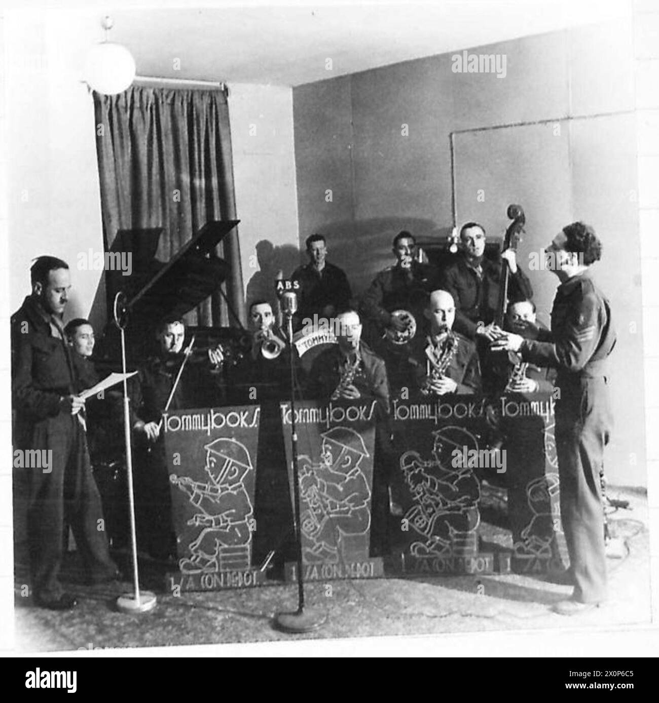 BRITISH FORCES STATION IN ROME - A South African dance band, including the 'Tommyboks' of No.1 S.A. Con.Depot, broadcasting from Studio 2, British Forces Radio Station, Rome. The band is under the direction of Sgt. Eddie Braden of 29 Parker Street, Manchester 4. On the left, announcing the programme, is Lieut. Bill Perkin of 'Beach Bungalow' Newquay, Cornwall. Photographic negative , British Army Stock Photo