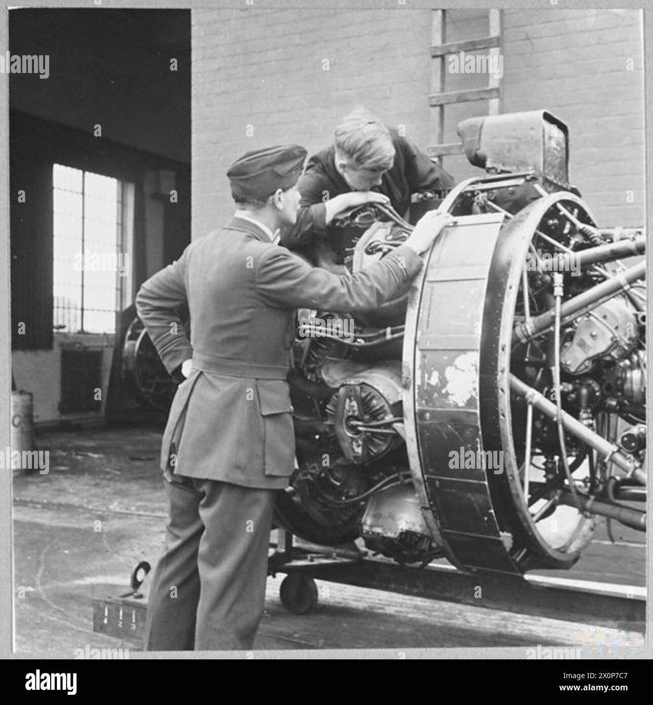 An RAF engineer officer inspects an aero engine under repair as part of ...