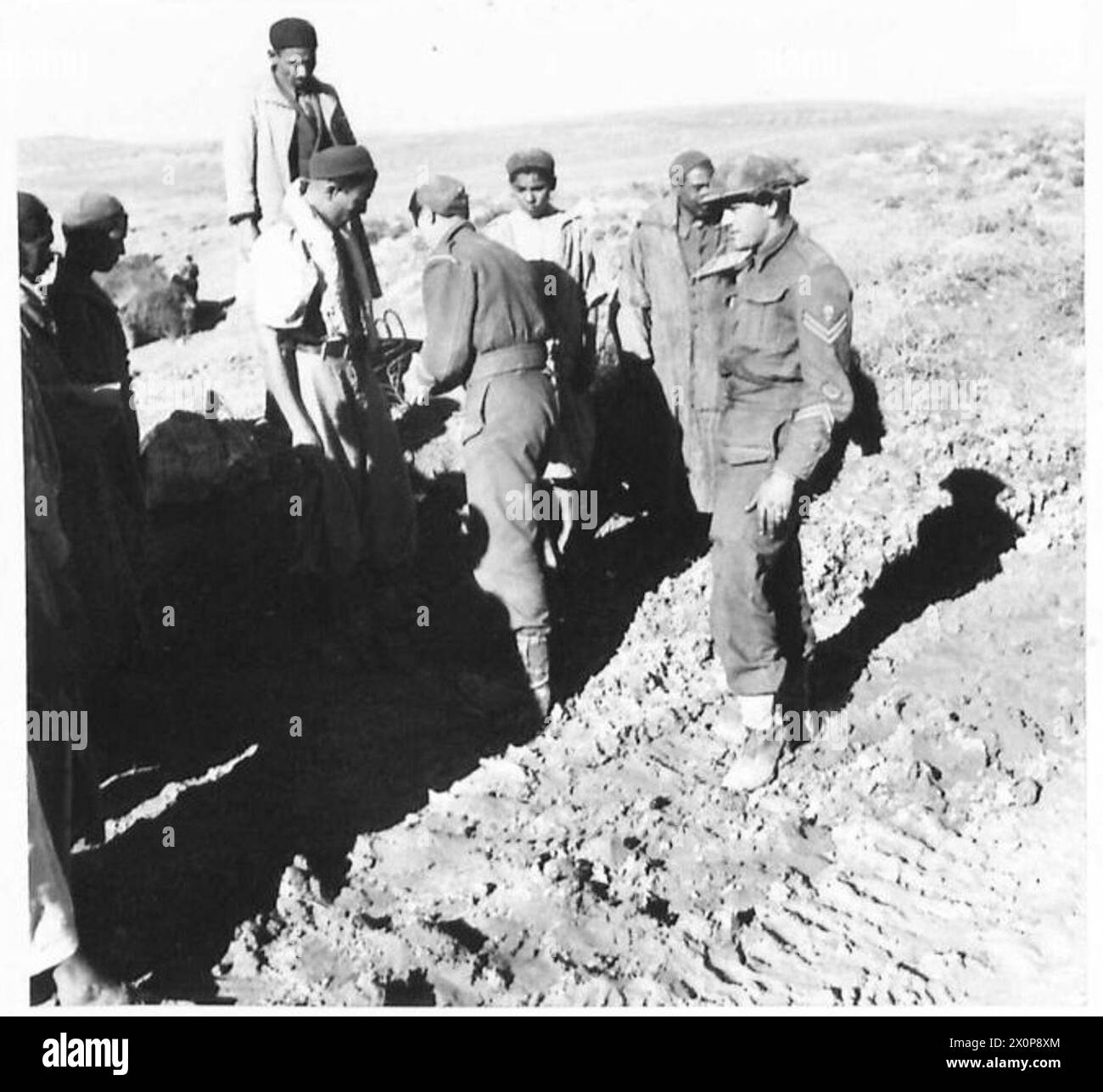 THE BRITISH ARMY IN THE TUNISIA CAMPAIGN, NOVEMBER 1942-MAY 1943 - Guardsmen of the 3rd Battalion, Grenadier Guards searching local Arabs in the frontline area near Medjez el Bab, December 1942. The soldier with his back to the camera is Drum Major Watling British Army, British Army, 1st Army, British Army, Grenadier Guards, British Army, Grenadier Guards, 3rd Battalion Stock Photo