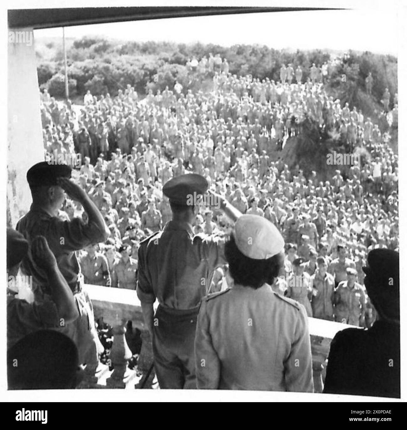 H.M. THE KING IN NORTH AFRICA - At a beach pavilion, troops assembled on the sands, and sang the National Anthem, as the King appeared on the balcony and took and salute. Photographic negative , British Army Stock Photo