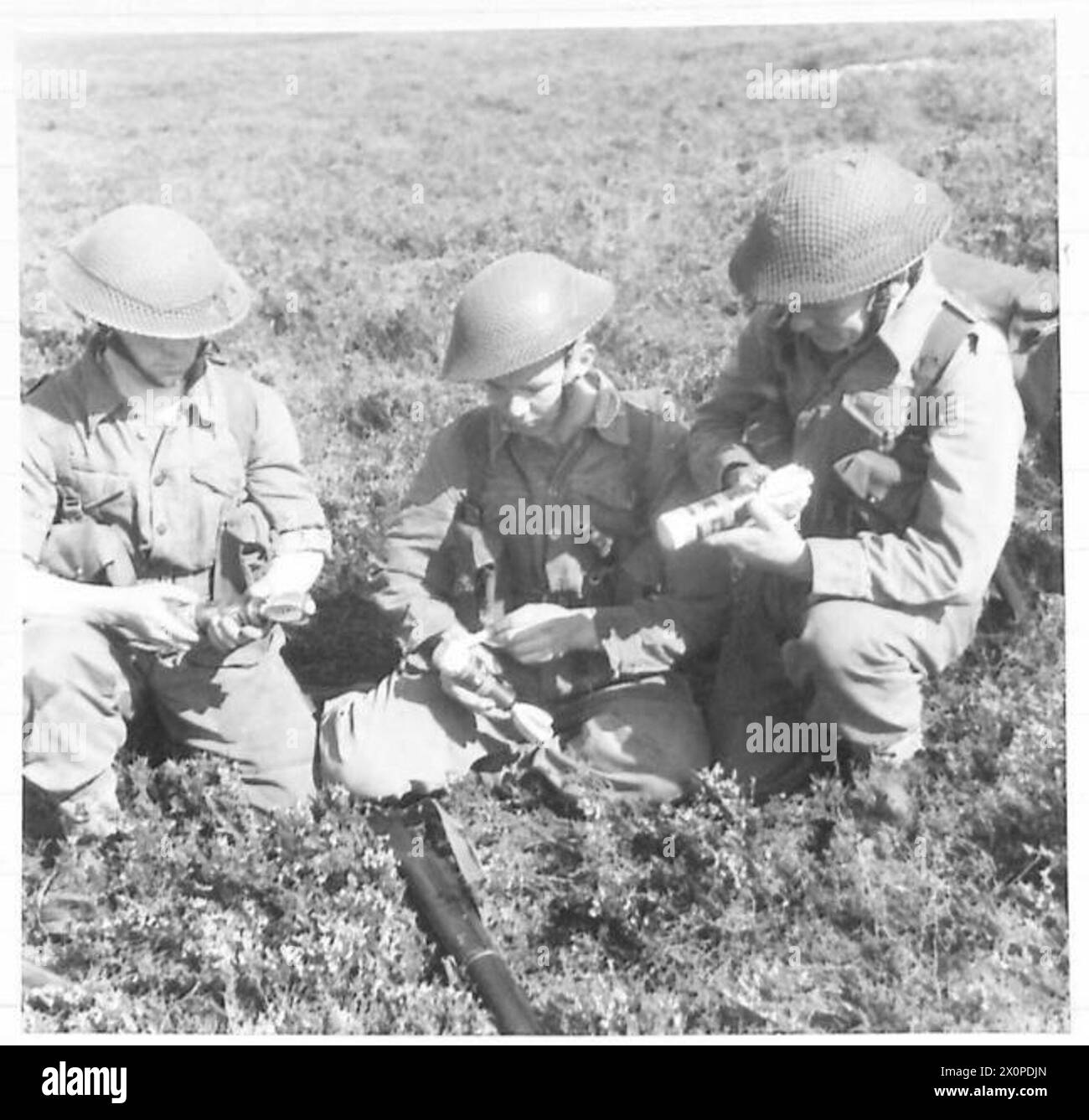 THEY ALL LEARN TO FIRE THE 2-INCH MORTAR - Troops examining H.E. (high ...