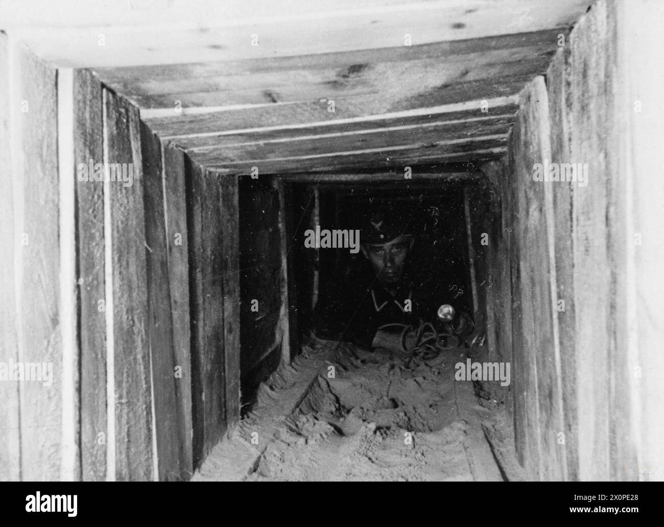 THE GREAT ESCAPE, MARCH 1944 - A German guard in the 'Harry' escape tunnel at Stalag Luft III, Sagan. Photograph probably taken in late March 1944 German Air Force Stock Photo