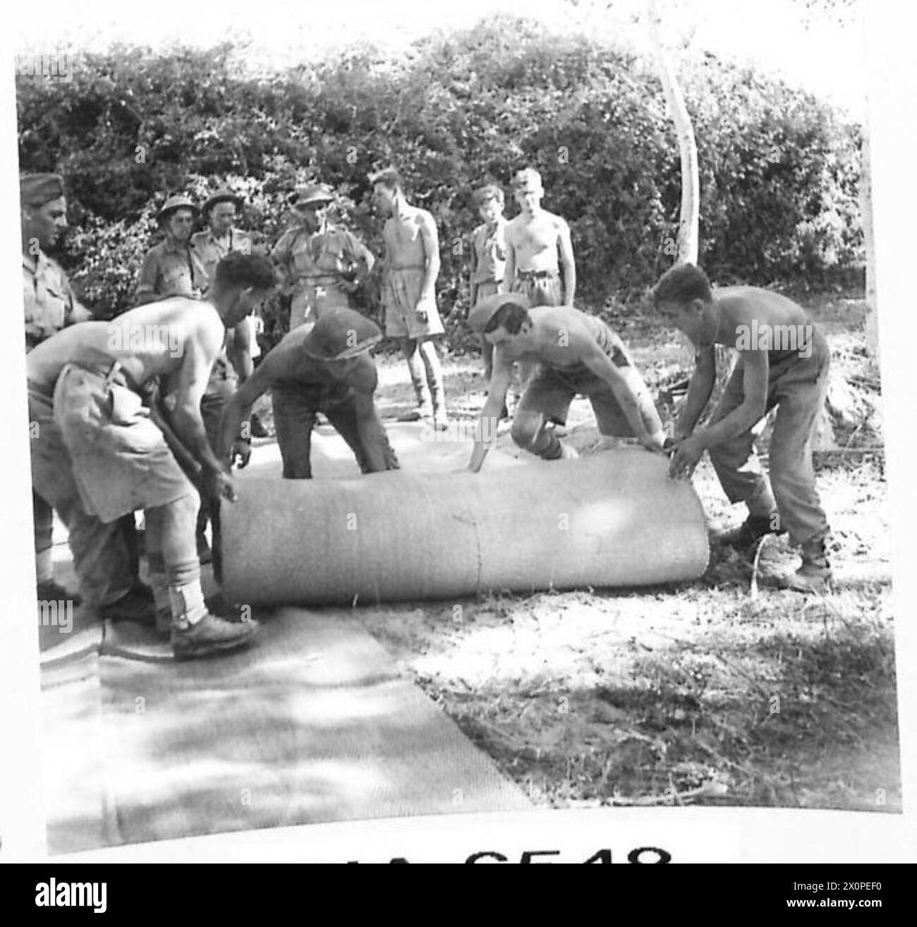 INVASION OF ITALY 'ITS AN ENGINEERS' WAR' - The matting is laid carefully, as its placing greatly influences the life of the finished road, it must be laid level and taut to do its job properly. Photographic negative , British Army Stock Photo