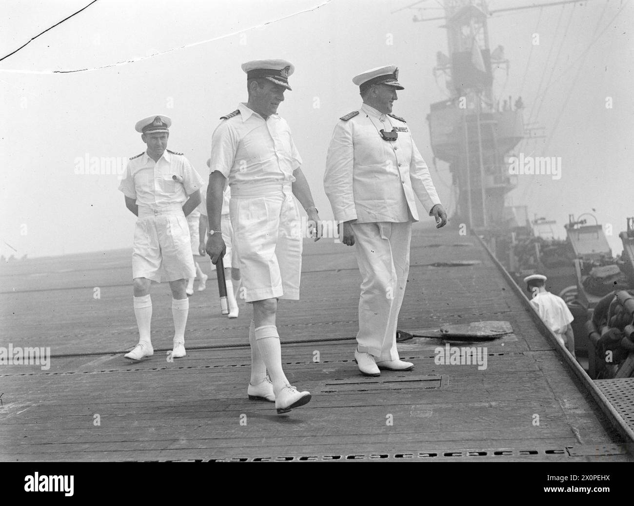 ADMIRAL TROUBRIDGE VISITS SEARCHER. AUGUST 1944, MALTA. DURING THE VISIT OF REAR ADMIRAL T H TROUBRIDGE, DSO AND BAR, TO THE ESCORT CARRIER HMS SEARCHER. - Admiral Troubridge (right) on SEARCHER's flight deck with Captain G O C Davies, RN, (centre) and Commander L J Sedwick, RN Stock Photo