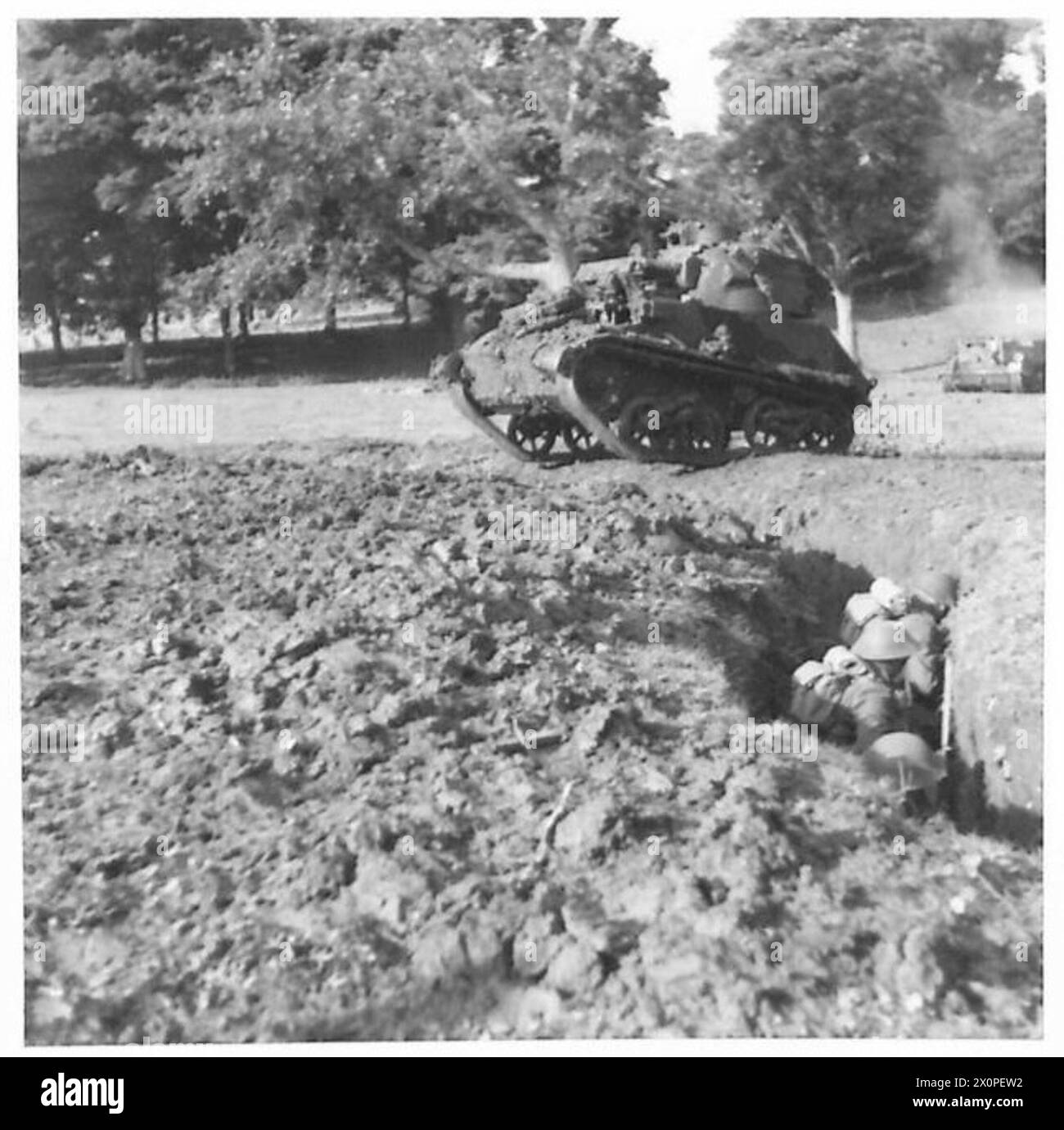 REALISITIC TRAINING A light tank crossing a trench. The troops keep