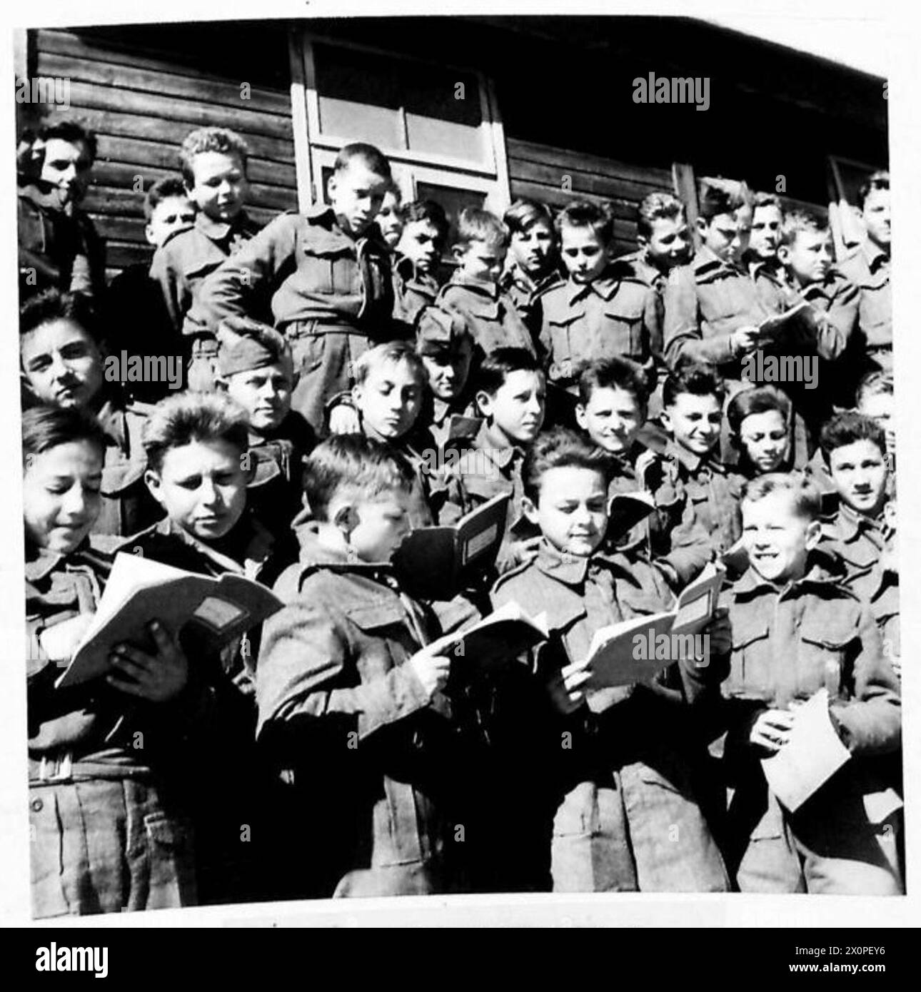 THE POLISH ARMY IN THE MIDDLE EAST, 1942-1943 - Outside the classroom, waiting for lessons to begin, the younger boys having a last minute look at their homeworks which they will shortly have corrected by their teachers. At Barbara Camp near Gaza in Palestine some thousands of young Poles are being trained and educated as cadet soldiers for the day when they will be able to join their seniors as accomplished fighting men in the struggle for the final liberation of their country.They are accepted at the cadet school from age six upwards, and in addition to military training, receive a full gene Stock Photo