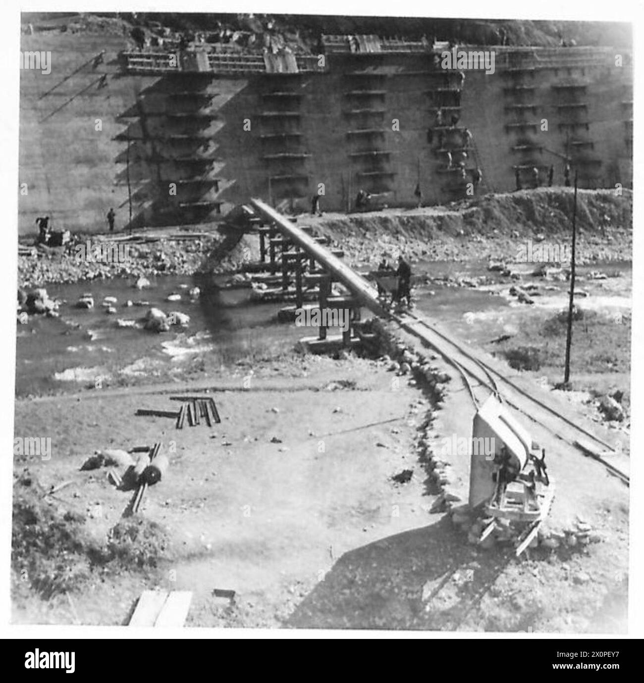 RAILWAY RECONSTRUCTION IN ITALY - Concrete revetting along a stretch of permanent way blown into the river near Carnagnanella. The concrete was laid from the bottom up, the wet concrete being passed up by a human chain from platform to platform. Photographic negative , British Army Stock Photo