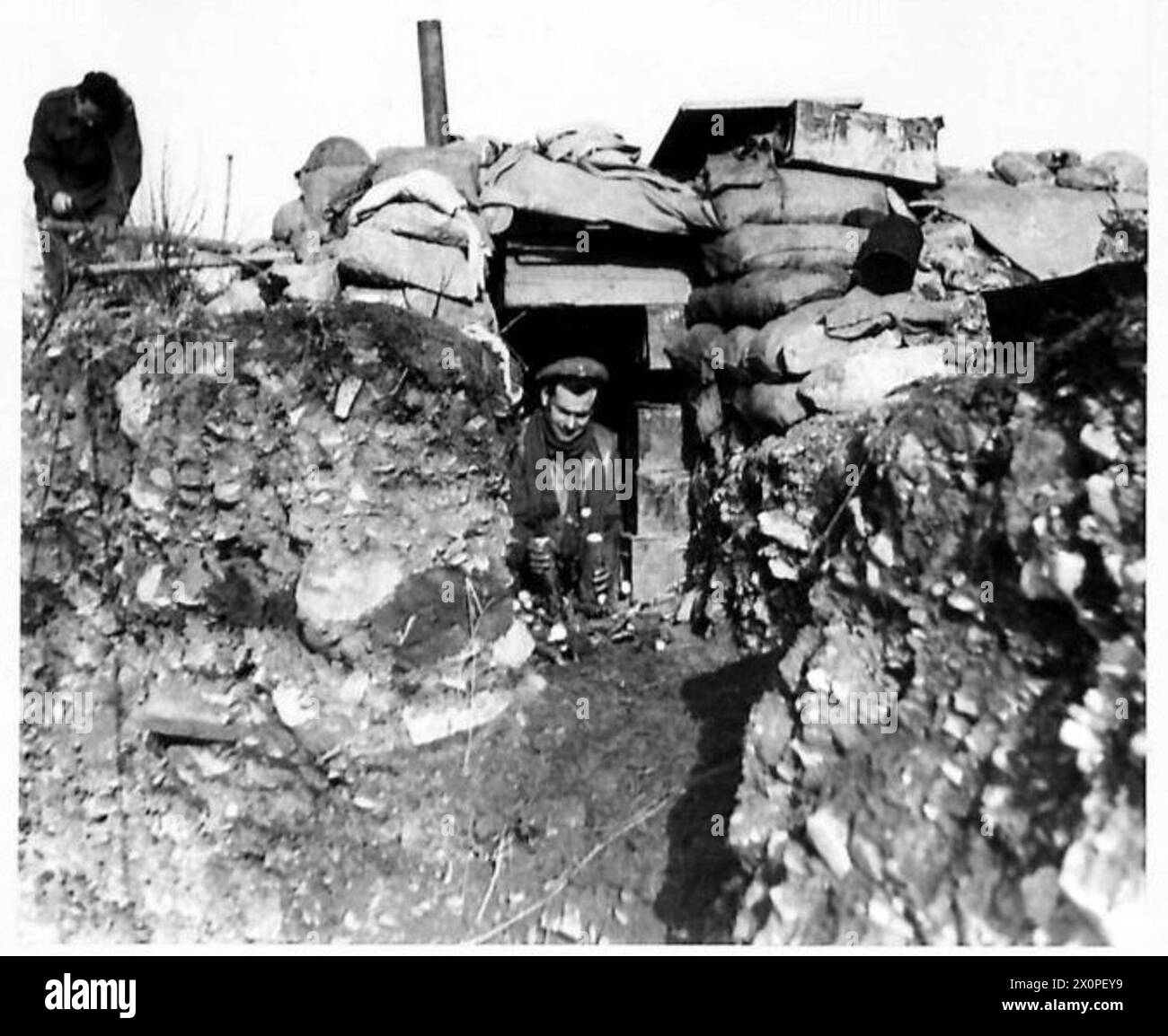 THE BRITISH ARMY IN NORTH AFRICA, SICILY, ITALY, THE BALKANS AND AUSTRIA 1942-1946 - Gnr. Doran of 37 Waverly Road, Exmouth, Devon collecting wood which he keeps handy in his doorway. All of these shelters have stoves. Photographic negative , British Army Stock Photo