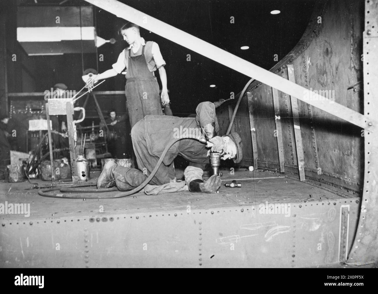 Ships Riveter A riveter works on a landing craft at a shipyard in 1942 during the ...