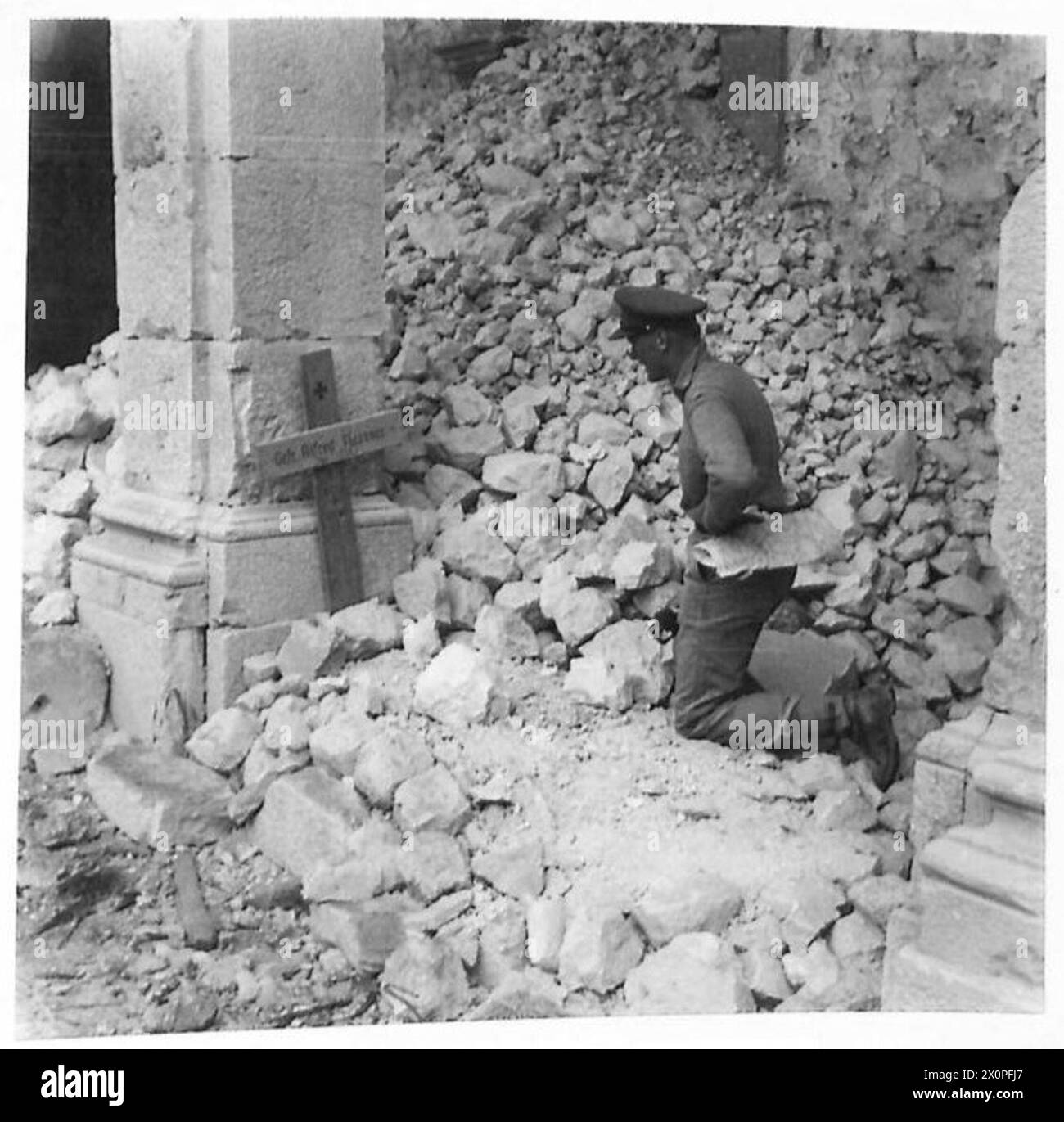 ALLIED ARMIES IN THE ITALIAN CAMPAIGN, 1943-1945 - Captain L. Q. T. Cooper of the 30th Field Regiment, RA, inspecting a grave of a German soldier, Gefreiter Alfred Flessner, in the Monte Cassino Abbey courtyard. Captain Cooper's home address was 44 Chomeley Park, Highgate, London British Army, Royal Artillery, Polish Army, Polish Armed Forces in the West, Polish Corps, II, 8th Army Stock Photo