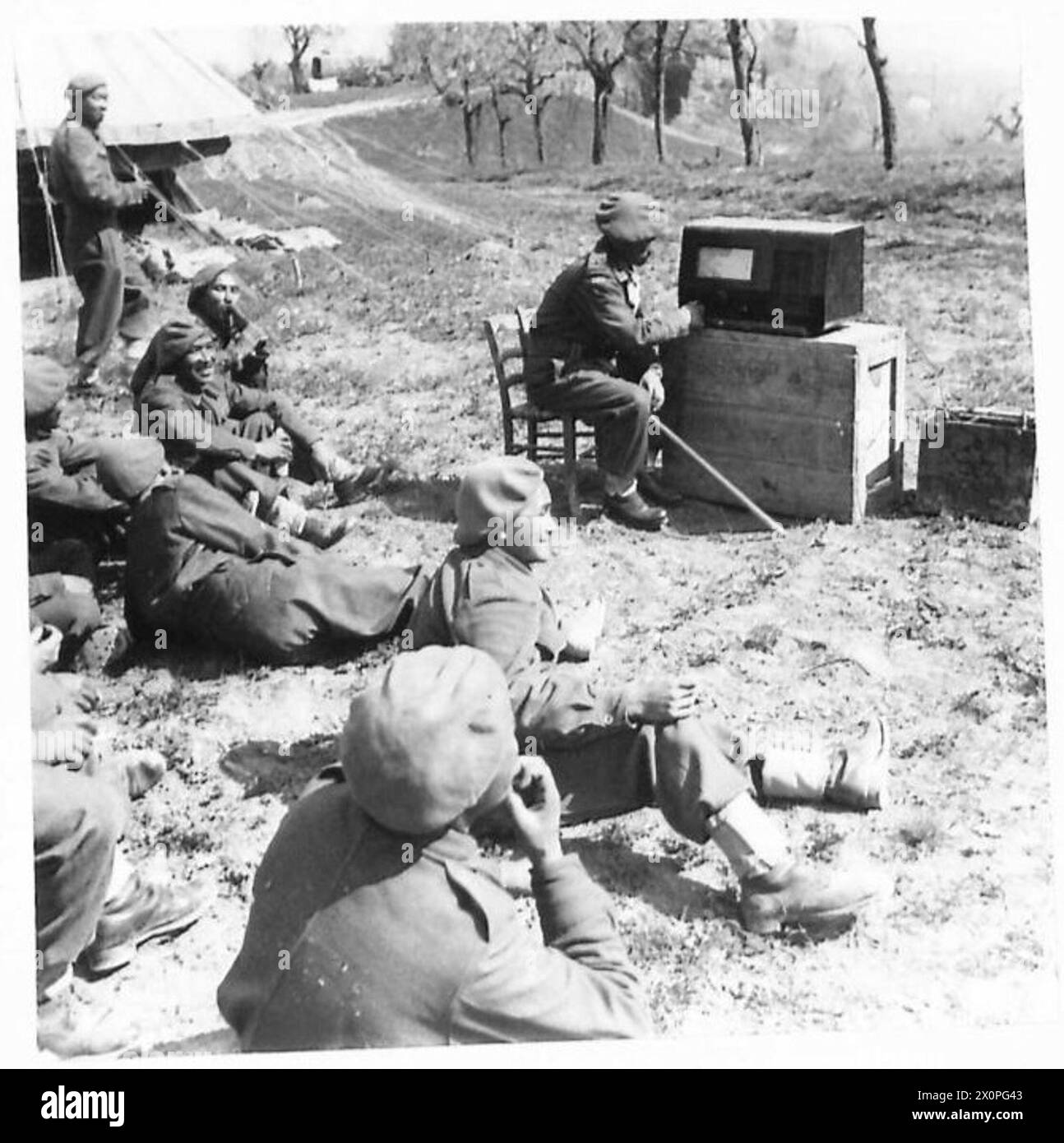 EIGHTH ARMY : THE GURKHAS - The Gurkhas are keen listeners to Indian programmes from the 8th Army Radio Station. They do not appreciate Western musical programmes. At the set is a Gurkha officer, Jemadue Jitbahadur Gurung of Nepal. Photographic negative , British Army Stock Photo