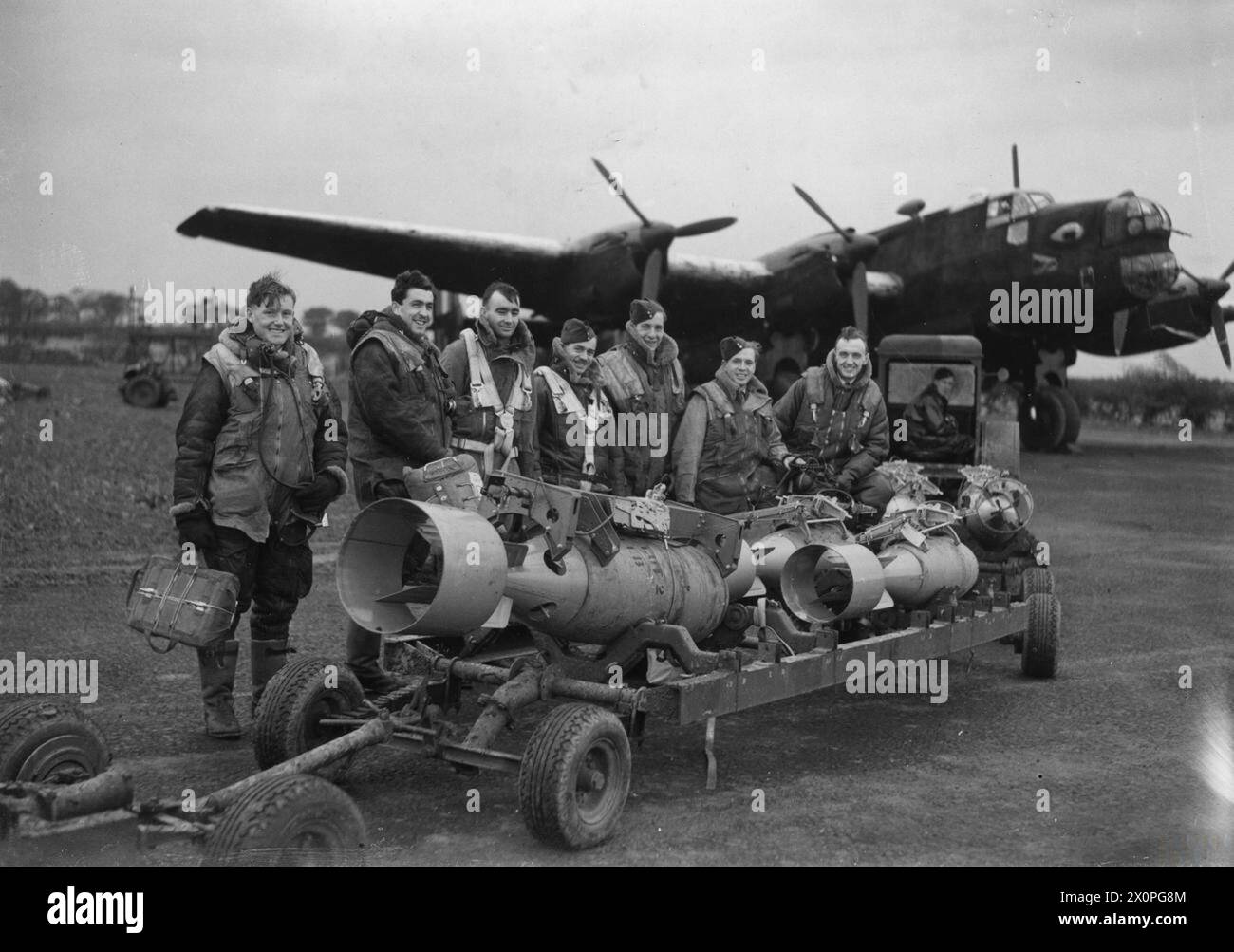 RAF BOMBER COMMAND - The crew of a Handley Page Halifax Mk II of No. 76 Squadron pose with a loaded bomb trolley at Middleton St. George, October 1941 Stock Photo