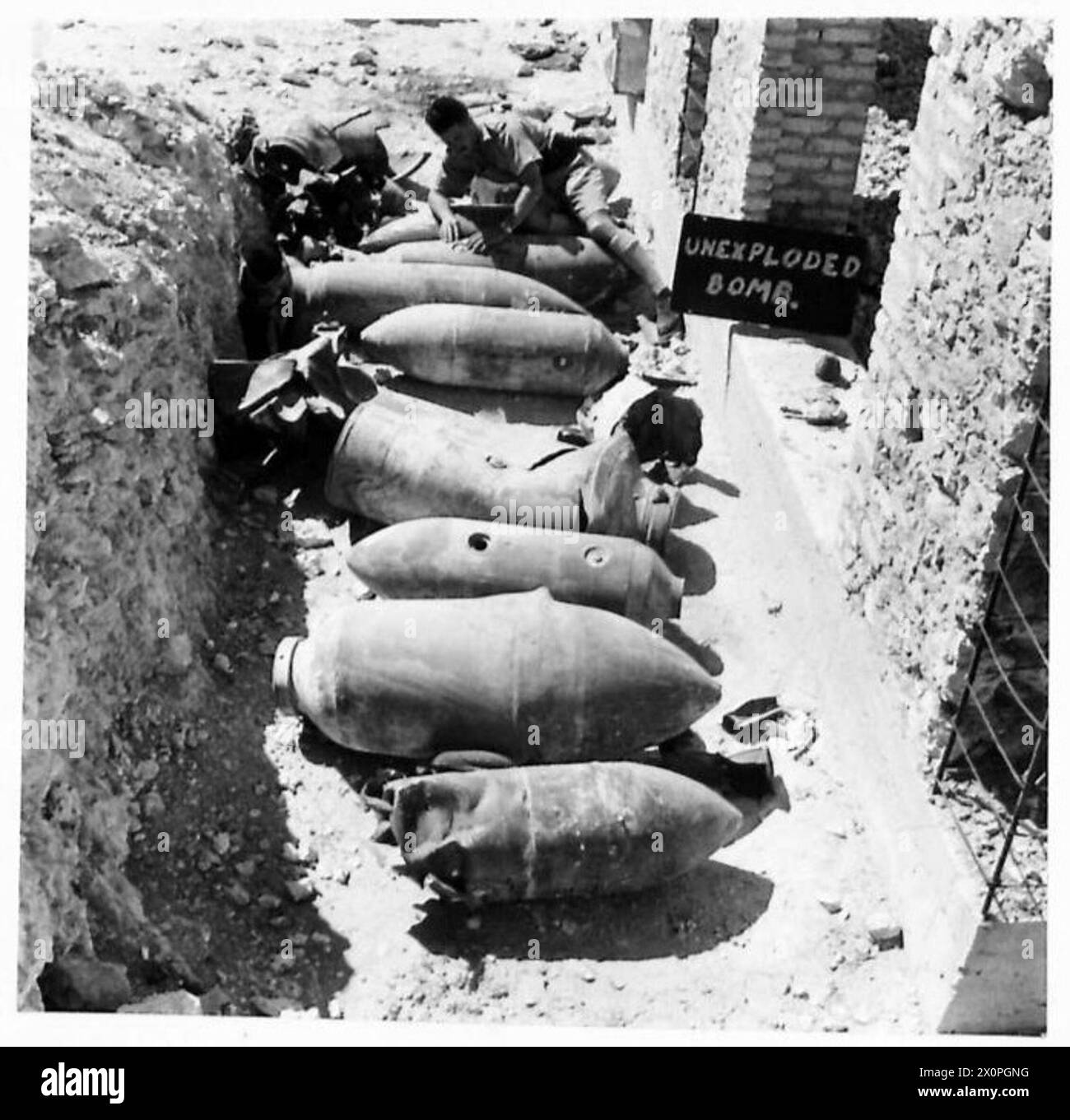 A BOMB DISPOSAL UNIT'S WORK - A storage of unexploded bombs showing an ...