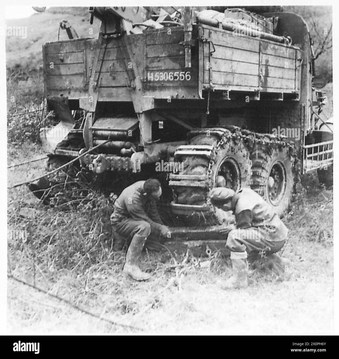 FIFTH ARMY : A NEW PROBLEM OF RECOVERY - Cfn. I. Rowam of Ardrishaie, Argyllshire, and Cfn. S. Shrimpton of Bletchley, Bucks, block the wheels of a Scammell recovery vehicle to prevent it from slipping in the mud. Photographic negative , British Army Stock Photo